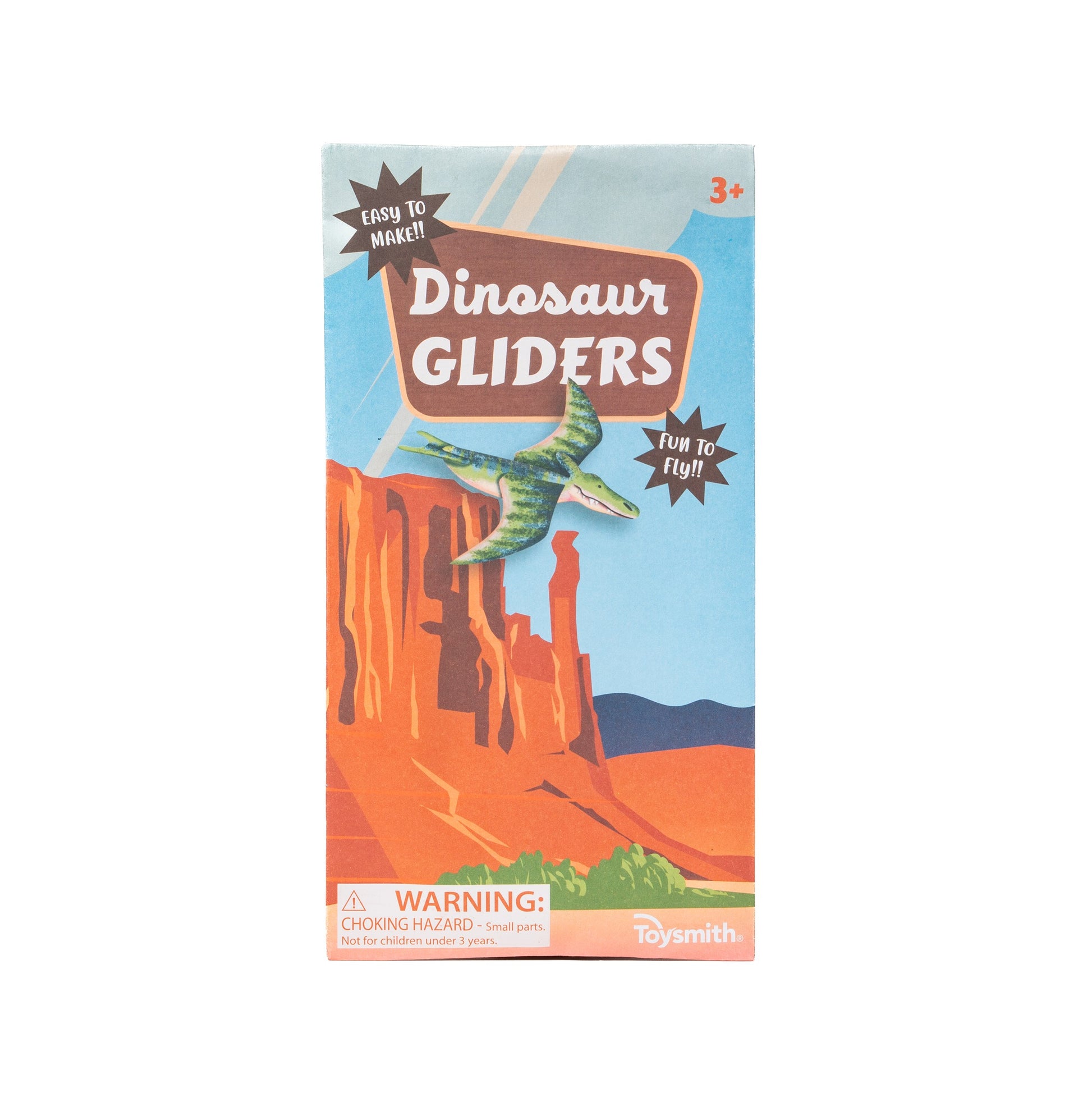 The Toysmith Dinosaur Gliders, Flying Toy comes in a colorful box showing a dinosaur airplane soaring over cliffs. Marked for ages 3+ with a choking hazard warning, the package reads "Easy to make! Fun to fly!" and is by Toysmith.