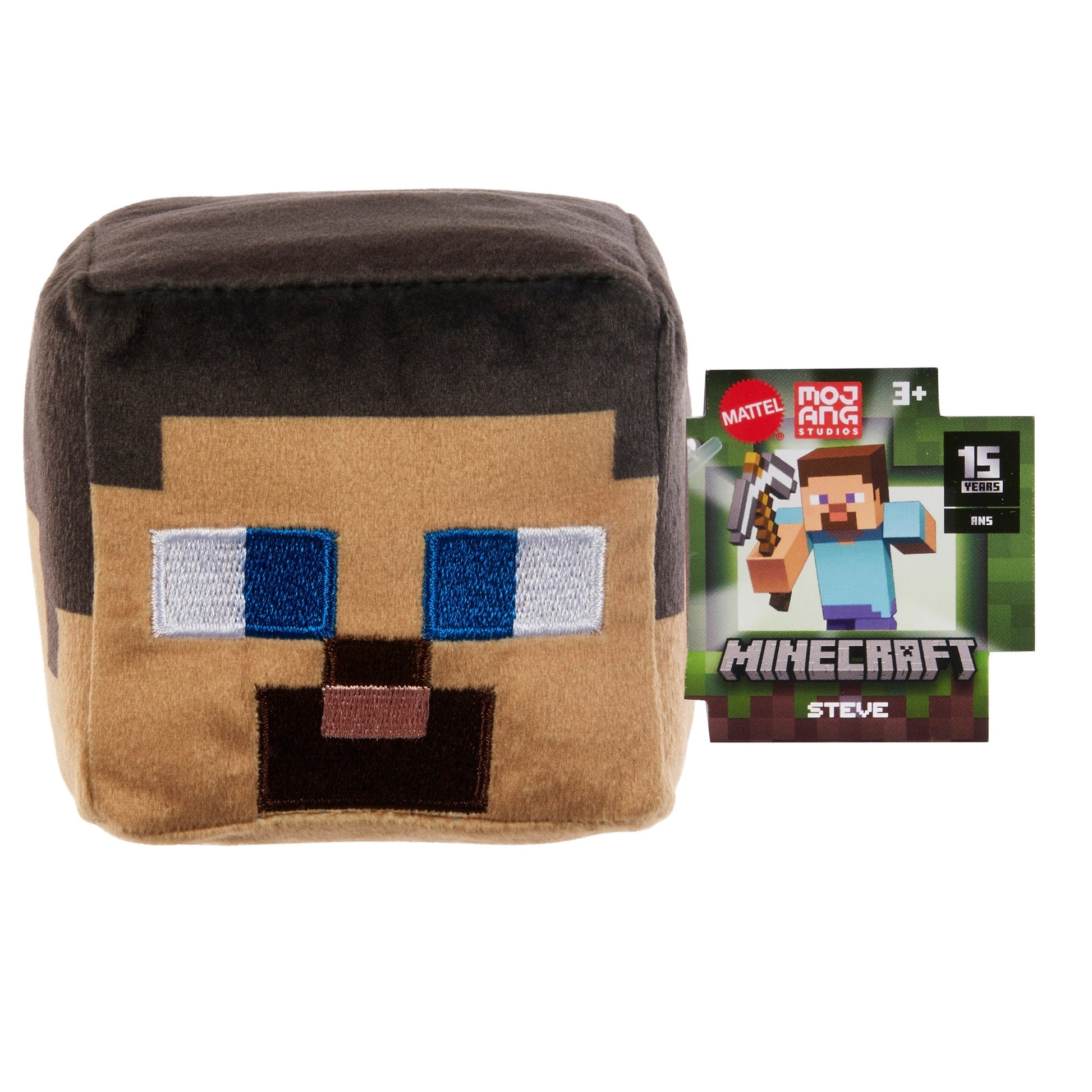The Mattel Minecraft Basic Block Plushie, featuring a square Steve design, sits beside its box, which shows Steve from the game, the Minecraft logo, and notes it's suitable for ages 3 and up.