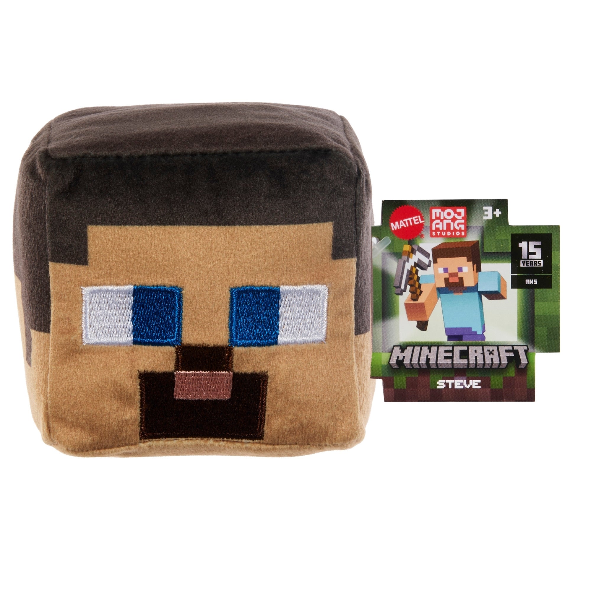 The Mattel Minecraft Basic Block Plushie, featuring a square Steve design, sits beside its box, which shows Steve from the game, the Minecraft logo, and notes it's suitable for ages 3 and up.