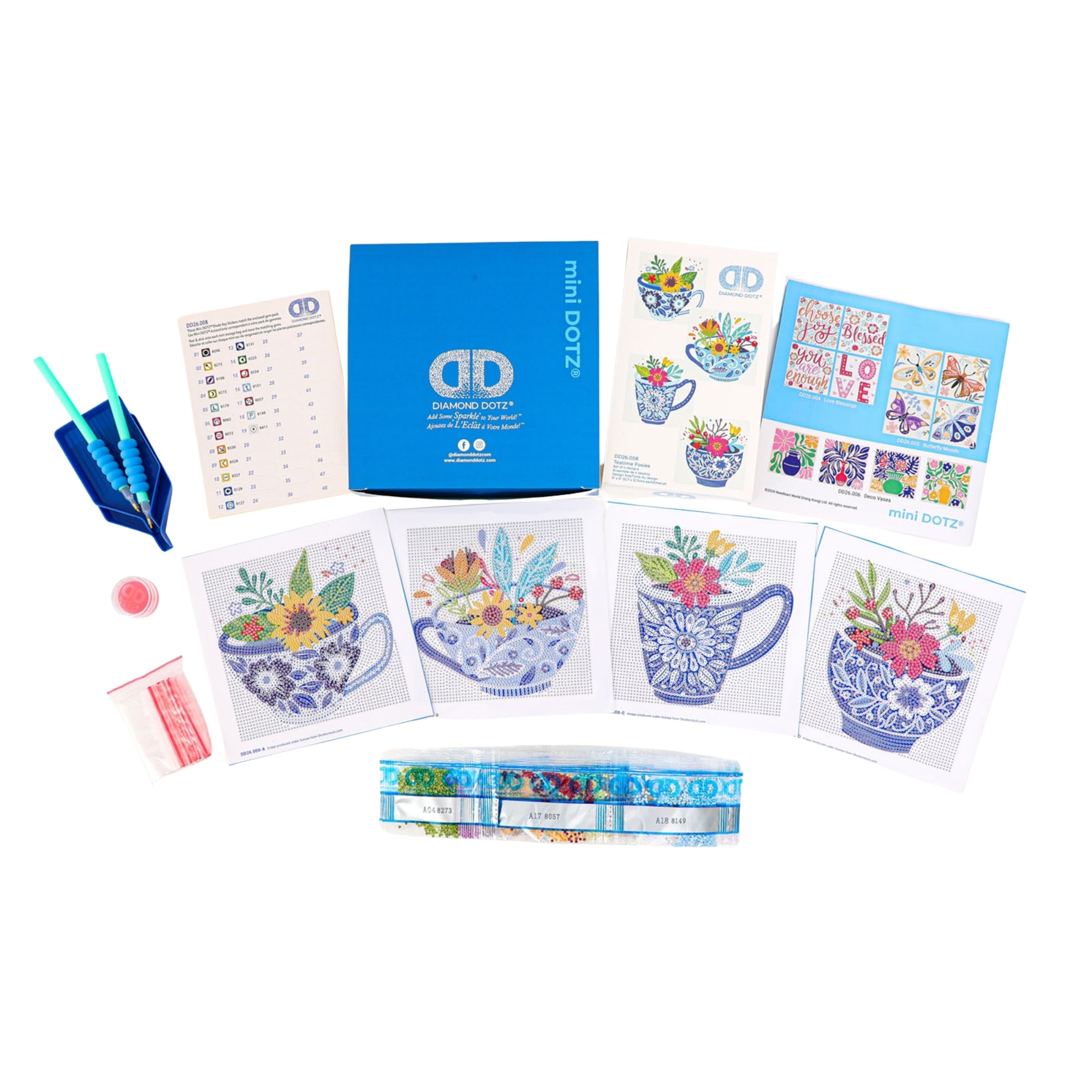Diamond Dotz Mini Dotz kit includes a blue box, tools, instructions, diamond packets, and five floral teacup canvas patterns. Also features two small prints and a strip with colorful designs for creative diamond painting fun.