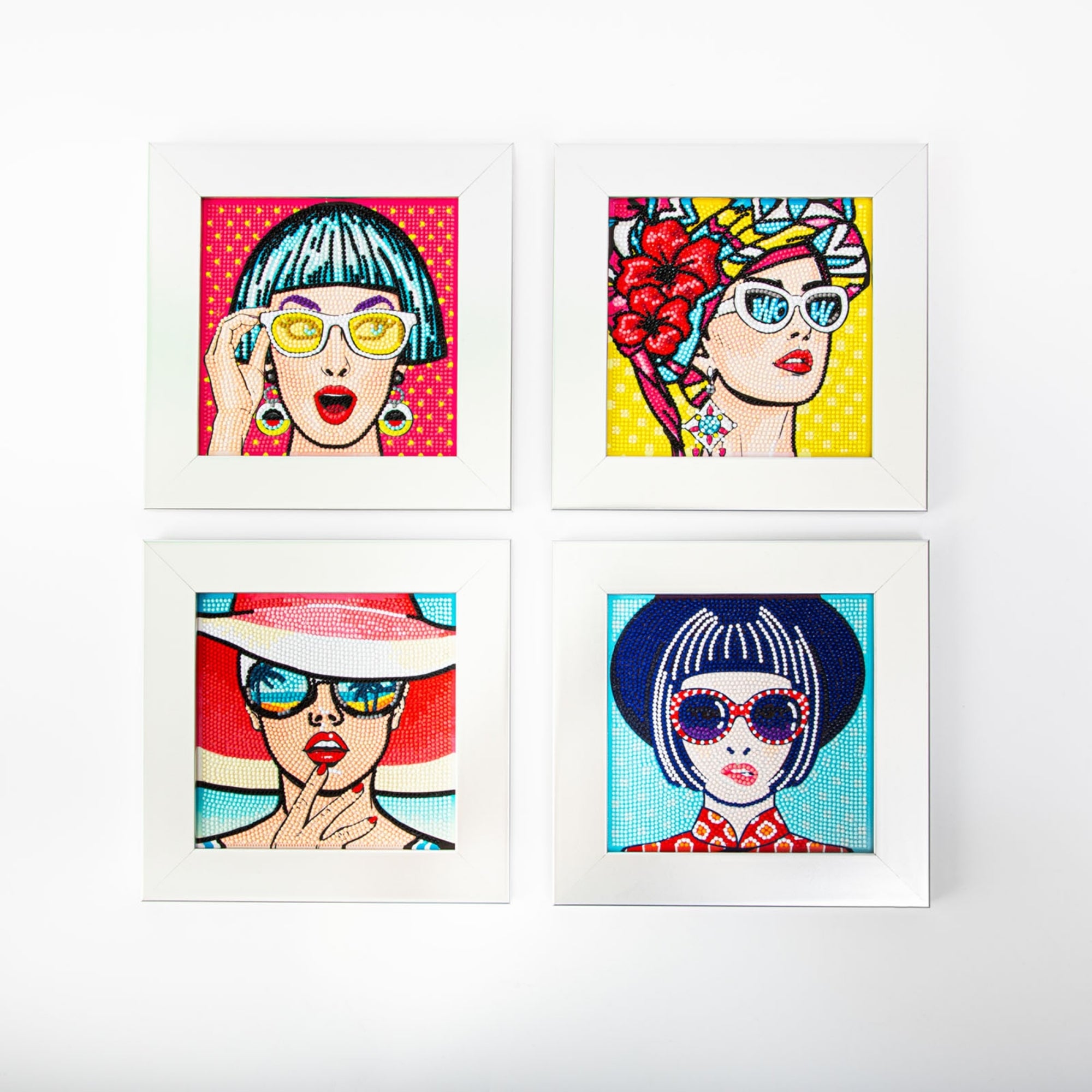 Four framed Diamond Dotz Mini Dotz portraits feature stylish women with various hairstyles, colorful sunglasses, unique accessories, and vibrant backgrounds, arranged in a two-by-two grid on a white wall.