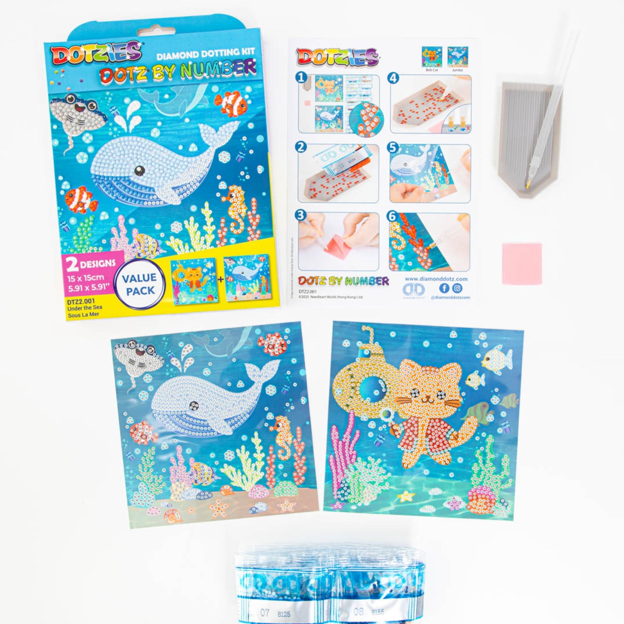 The Diamond Dotz Dotz By Number kit features whale and cat underwater scenes. Includes box, instructions, dotting pen, tray, wax pad, two sea-themed canvases, and colored diamond gem rolls.