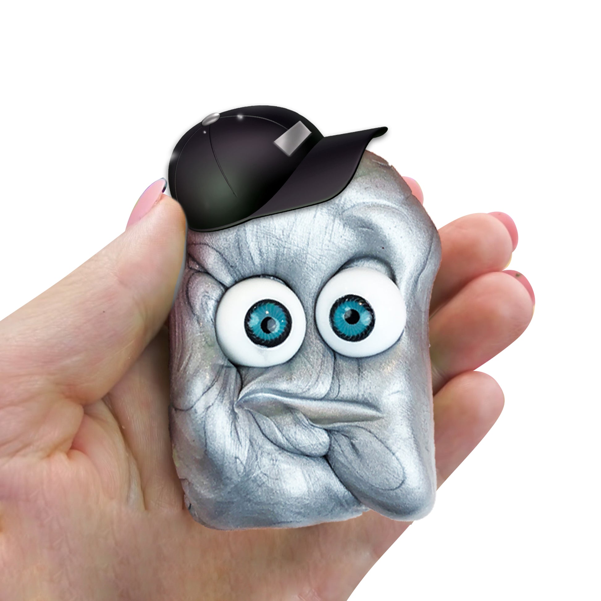 A hand holds a silver, putty-like blob with cartoon eyes, a puckered mouth, and a black cap—one of the fun characters from Doctor Squish Putty Buddies Asst. 21ct CDU.