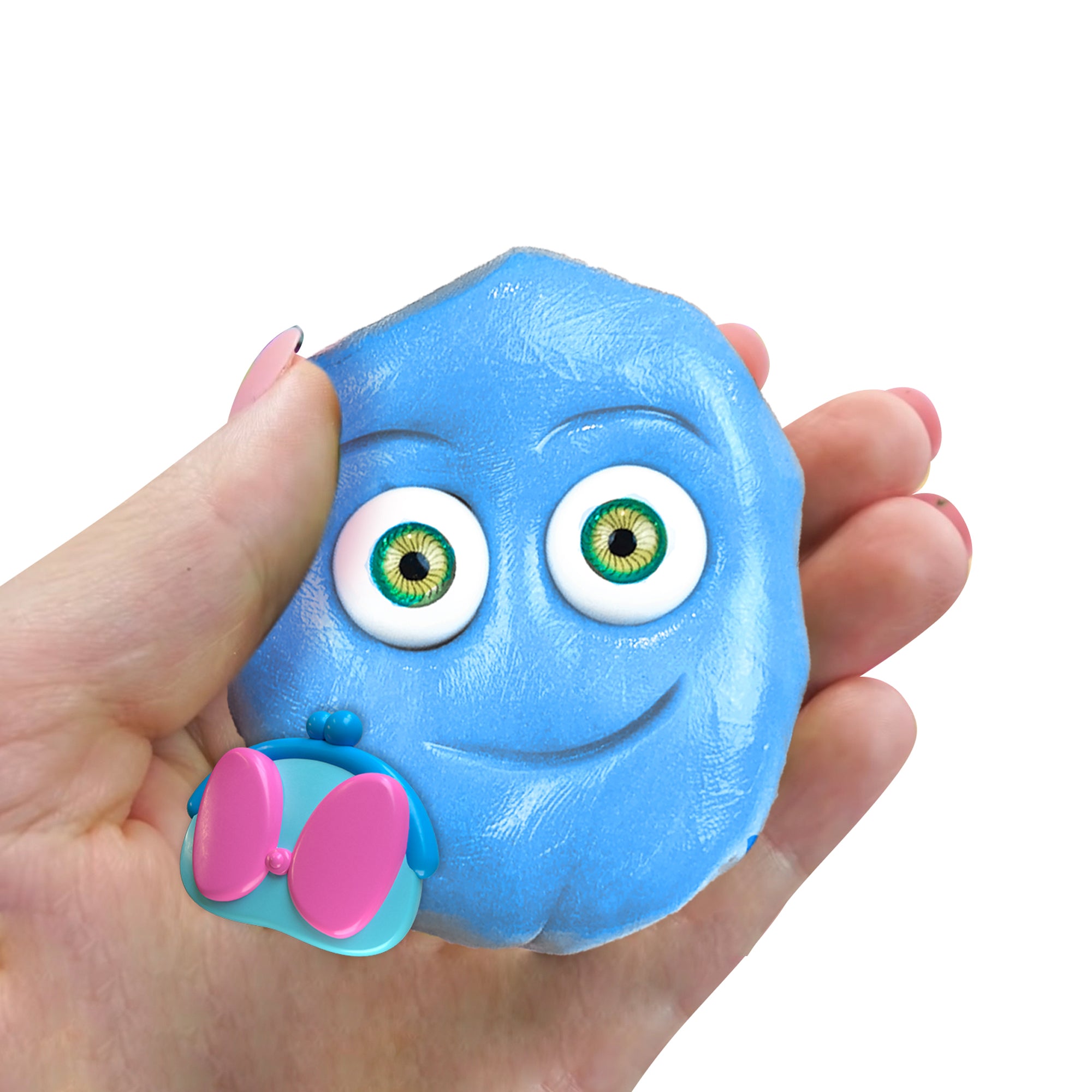 A hand holds a blue, round Doctor Squish Putty Buddies Asst. 21ct CDU character with big cartoon eyes, a smile, and a pink-and-blue purse near its face against a white background.