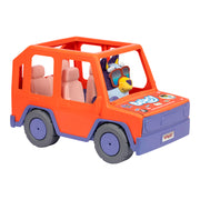 The Bluey Buddies Big Heeler 4WD Car Playset features an orange and purple SUV with four pink seats, a Bluey plush character in the driver’s seat, “Bluey” on the hood, and cartoon images on the front.