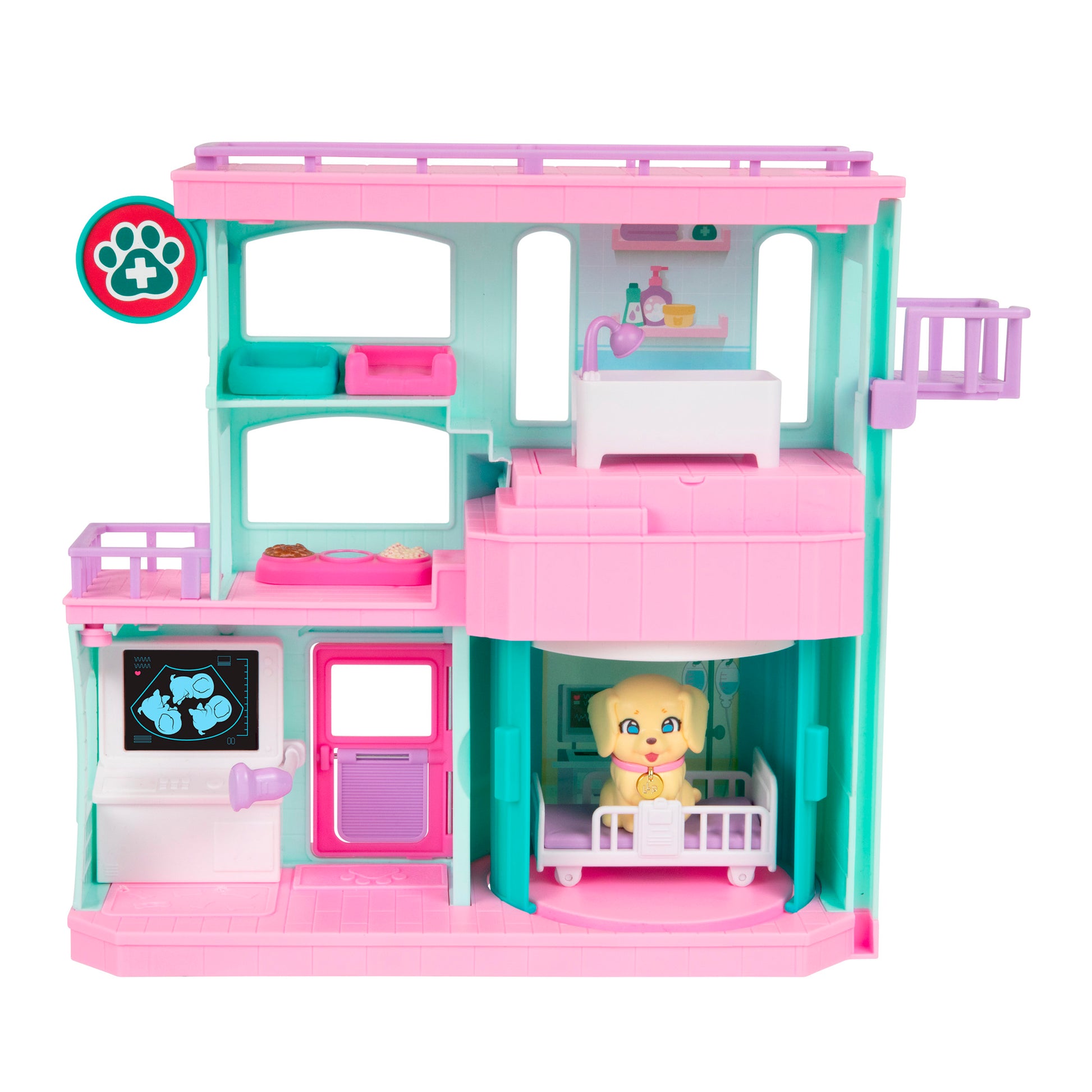 The LLP Mama Surprise Families Veterinarian Playset is a colorful plastic set with pink, teal, and purple details, featuring a small yellow dog in a crib, an X-ray computer screen, clinic furniture, and pet care accessories.