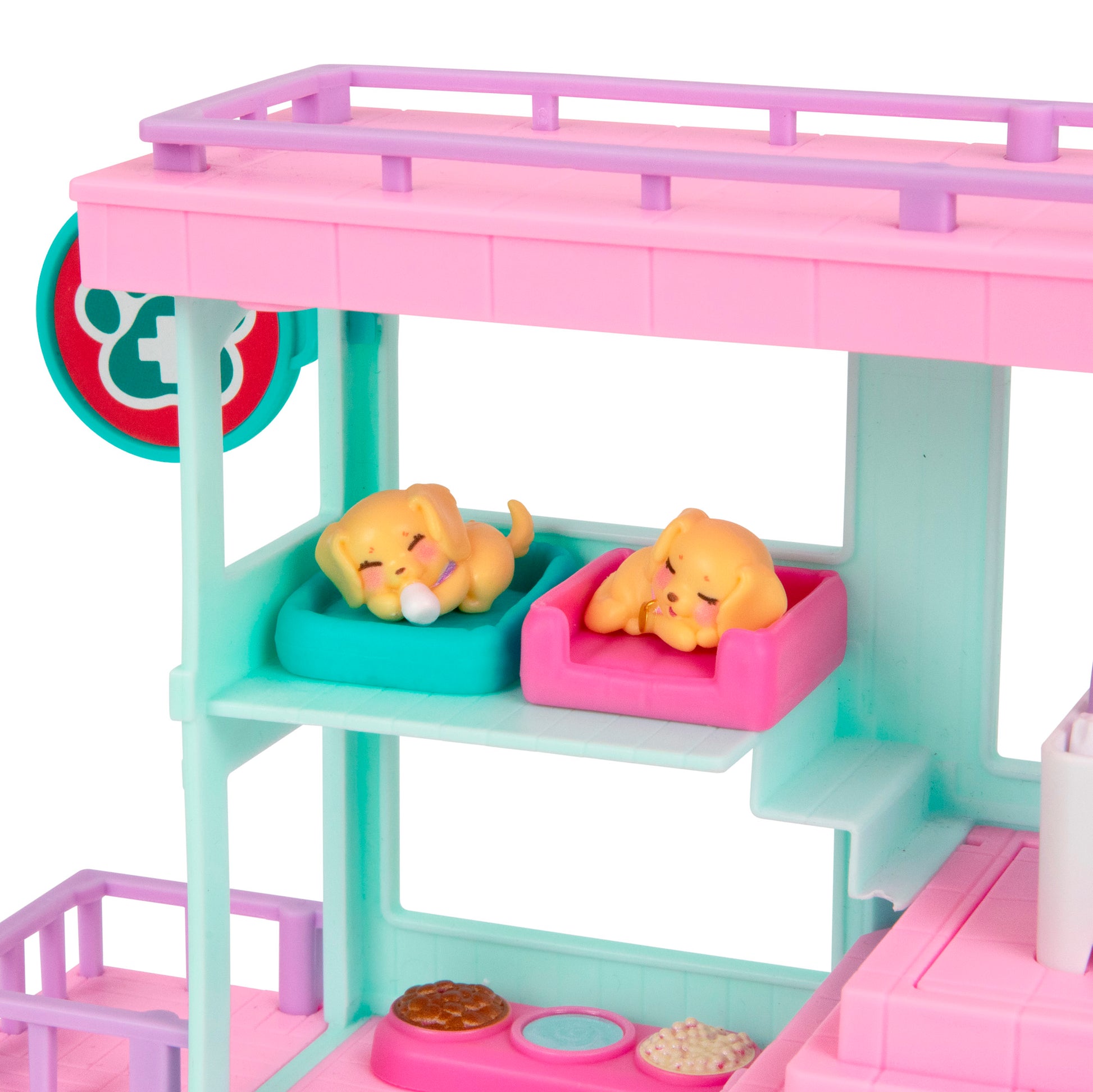 Two small yellow toy puppies rest on teal and pink beds in the pastel-colored LLP Mama Surprise Families Veterinarian Playset, which features a balcony, food dishes, and is perfect for imaginative pet care fun.