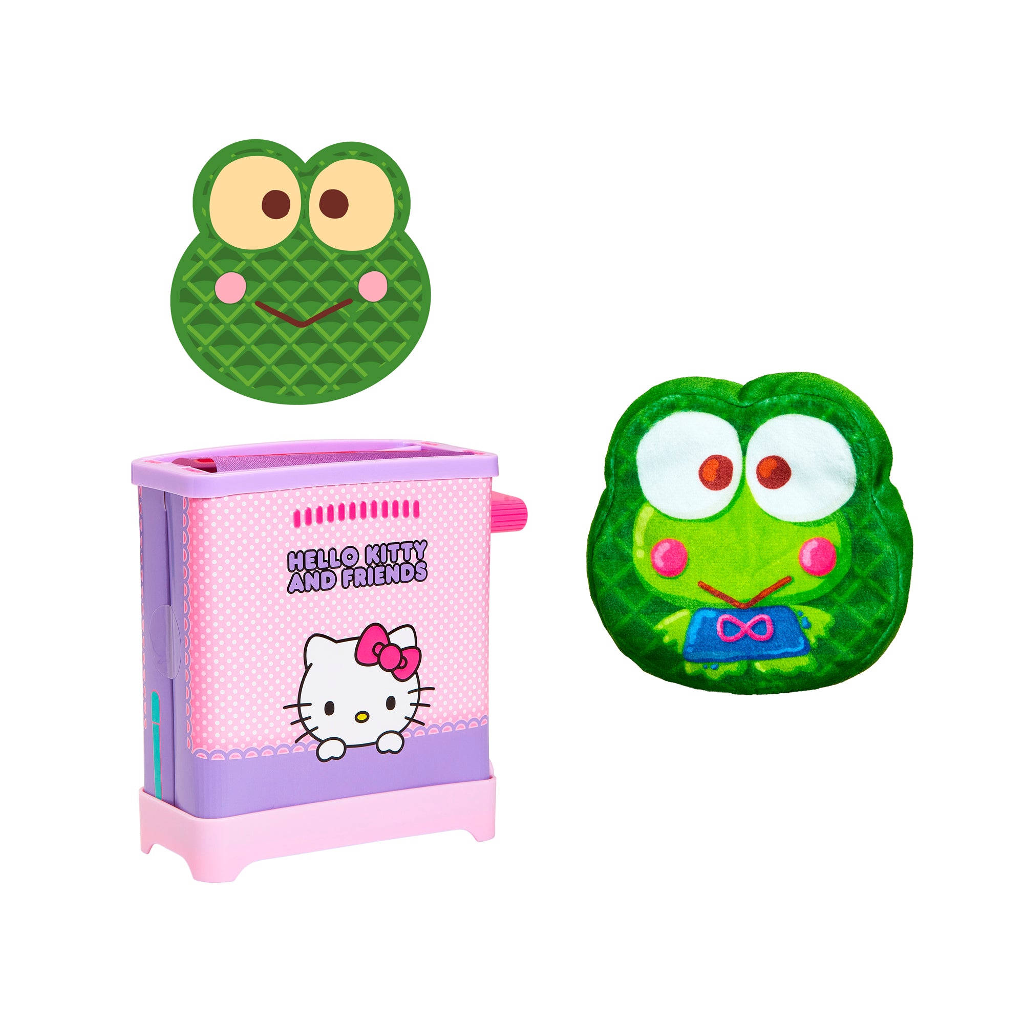 The Cookeez Makery Hello Kitty & Friends Toasty Treatz makes cute green Keroppi-shaped waffles with big eyes and rosy cheeks, perfect for a fun Sanrio-themed breakfast alongside a pink and purple Hello Kitty waffle maker.