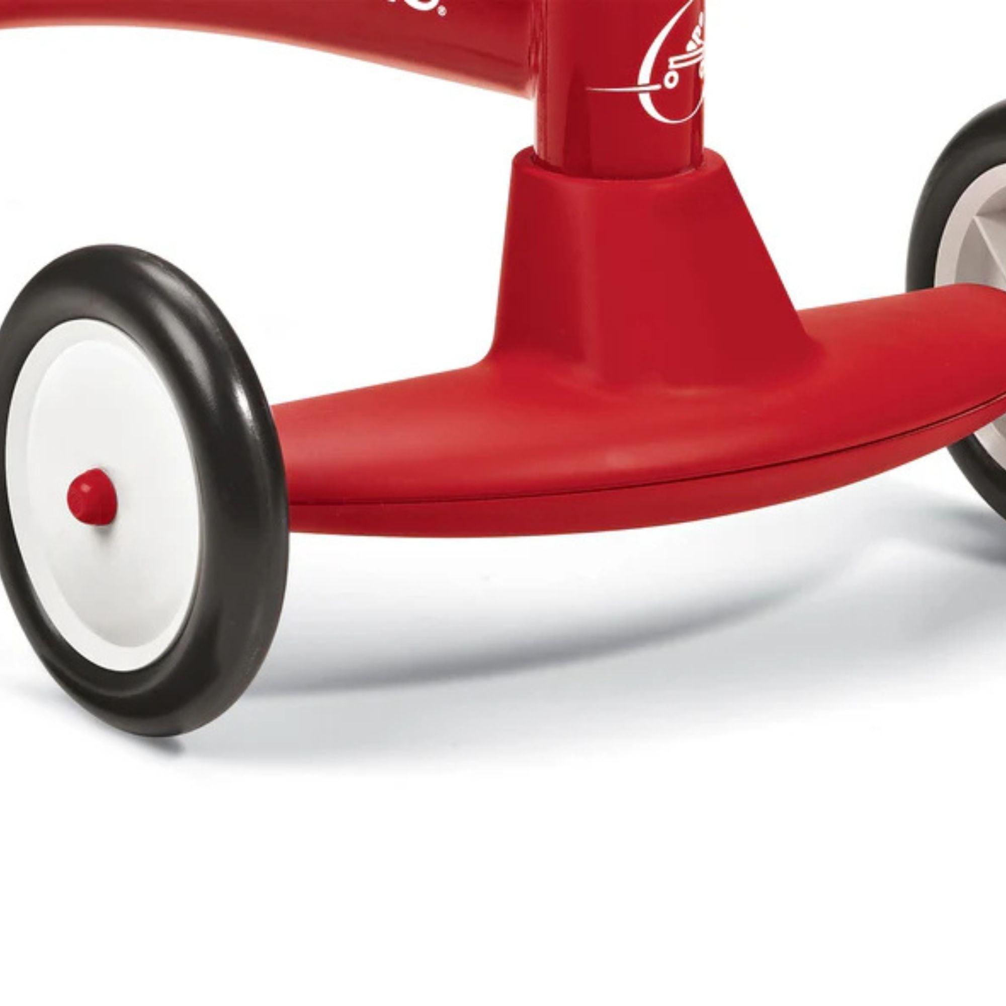 Close-up of the lower part of the Radio Flyer Scoot About ride-on by Radio Flyer, highlighting two black and white wheels and part of its red frame.