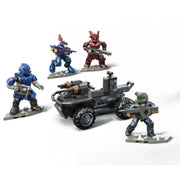Four armored Mega Blocks Halo figures in blue, red, purple, and green, each with weapons, surround a small gray vehicle with a mounted gun from the Mega Blocks Small Vehicles Collection, posed for battle.
