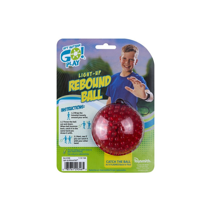 The GO! Play GO! Light-Up Rebound Ball comes in retail packaging with a smiling boy on a blue and green card displaying instructions and details. The red ball is visible in clear plastic—ideal for backyard fun.