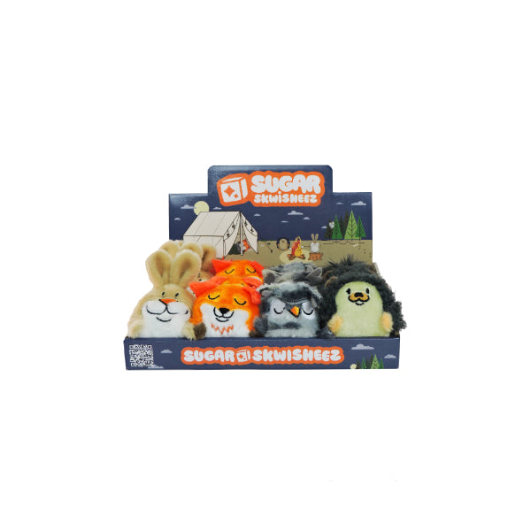 Four sensory plush animal toys—a bunny, fox, raccoon, and hedgehog—from the Tree Huggers Series 1 are displayed in a blue Sugar Skwisheez box with a camping scene. Ideal for stress relief and cozy cuddles.