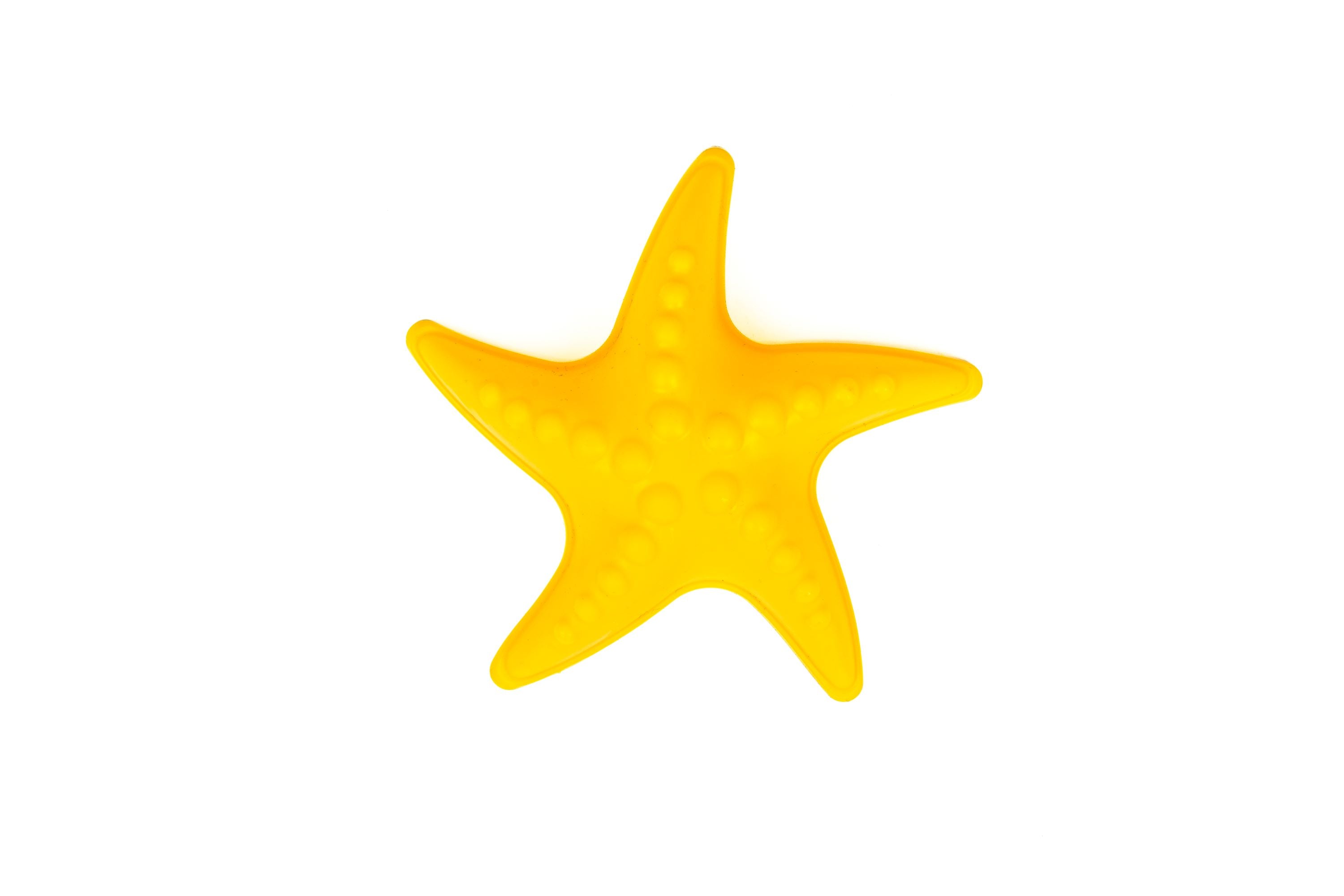A bright yellow starfish with raised bumps sits centered on a plain white background, resembling shapes from the Toysmith 6pc Set Pink Sand Bucket Set.
