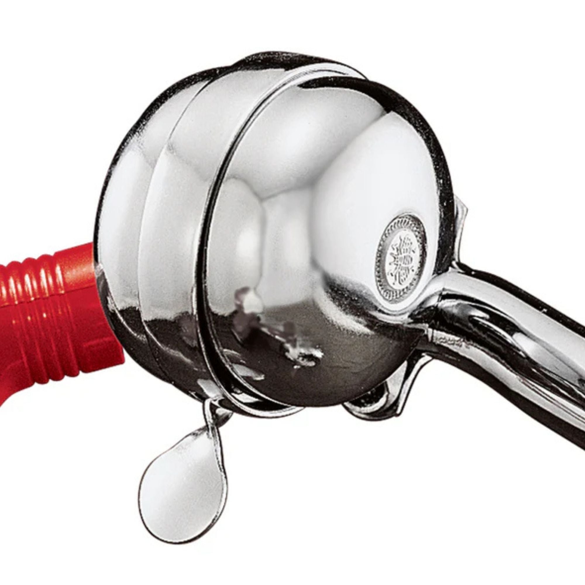 Close-up of a shiny silver bell mounted on the handlebars of the Radio Flyer Classic Red Dual Deck Tricycle, with a red handgrip visible. The bell includes a lever for ringing.