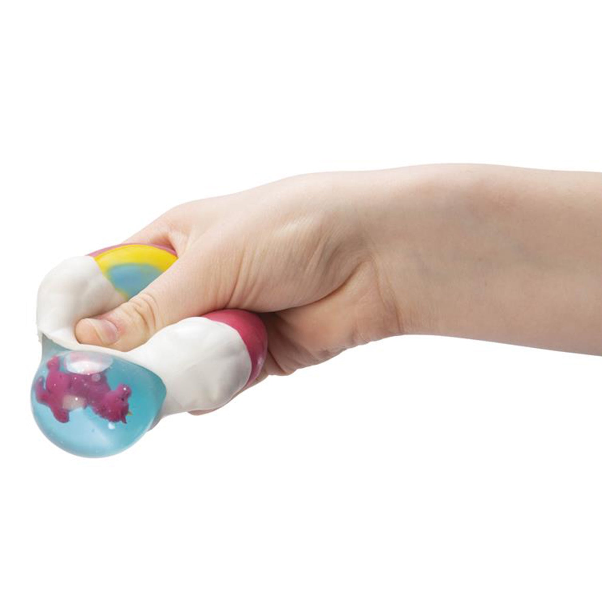A hand squeezes the Toysmith Peek-A-Boo Unicorn Squeeze, a stress ball with a white and rainbow exterior that reveals a blue transparent section with a small pink unicorn inside. Assorted styles; no color selection.