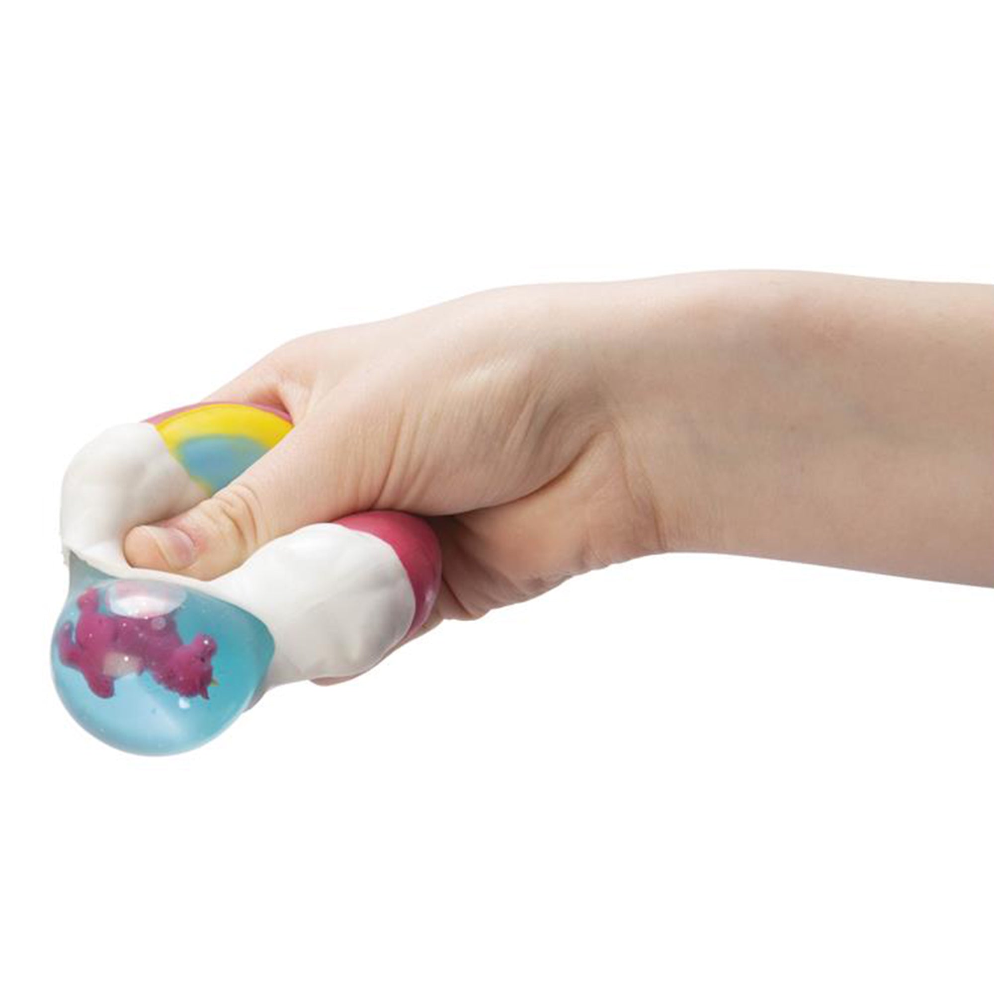 A hand squeezes the Toysmith Peek-A-Boo Unicorn Squeeze, a stress ball with a white and rainbow exterior that reveals a blue transparent section with a small pink unicorn inside. Assorted styles; no color selection.