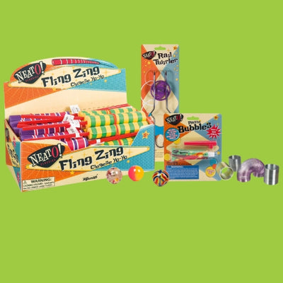 A display of colorful retro toys on a green background, including Fling Zing Chinese yo-yos, a Rat Twirler, Plastic Bubbles kit, bouncy balls, jacks, and a small slinky.