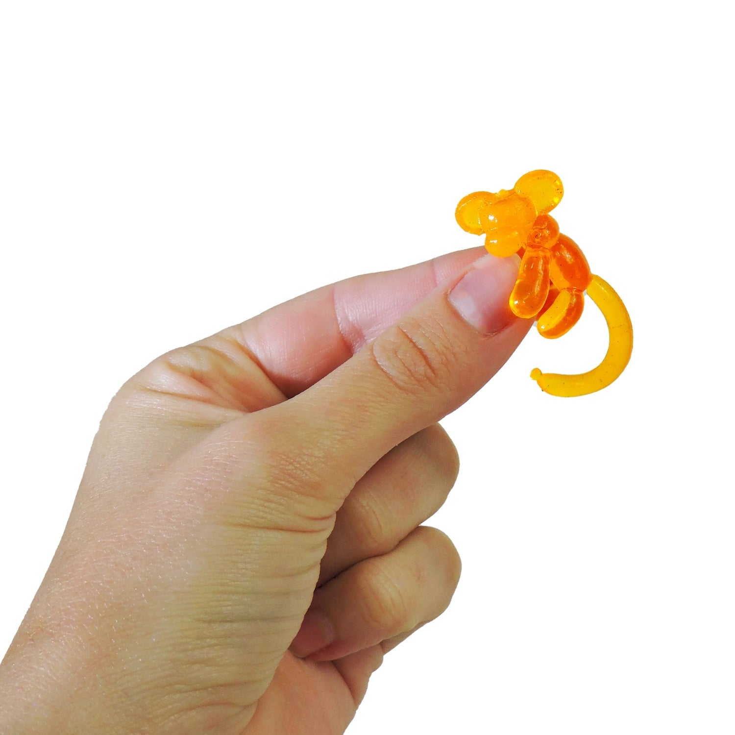 Hand holding a small orange object against a white background