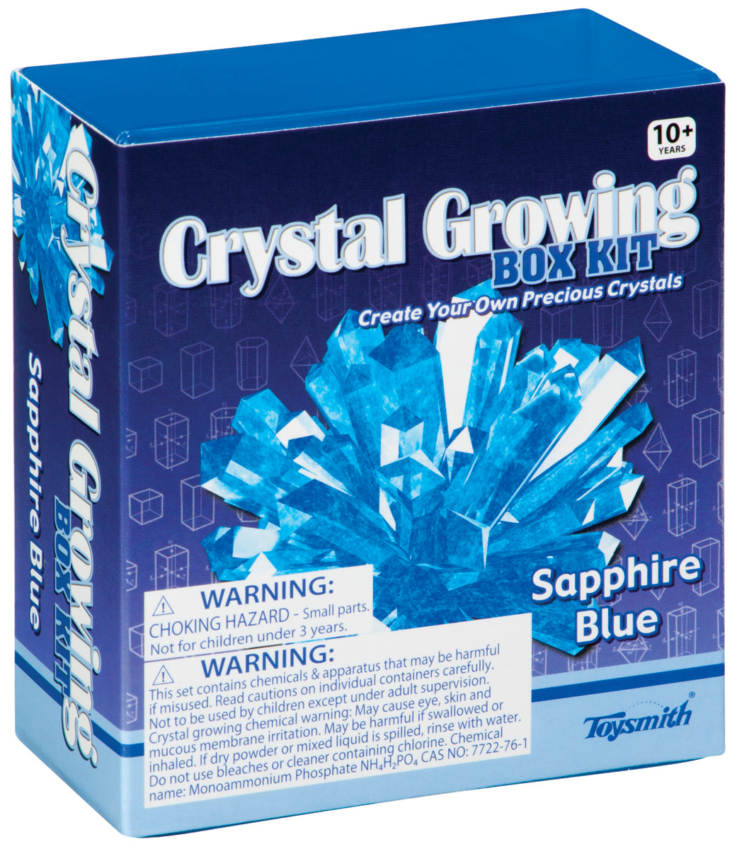 A blue Toysmith Crystal Growing Kit box for ages 10+ features an image of blue crystals, the Toysmith logo, and front warnings for choking hazard and chemical safety.
