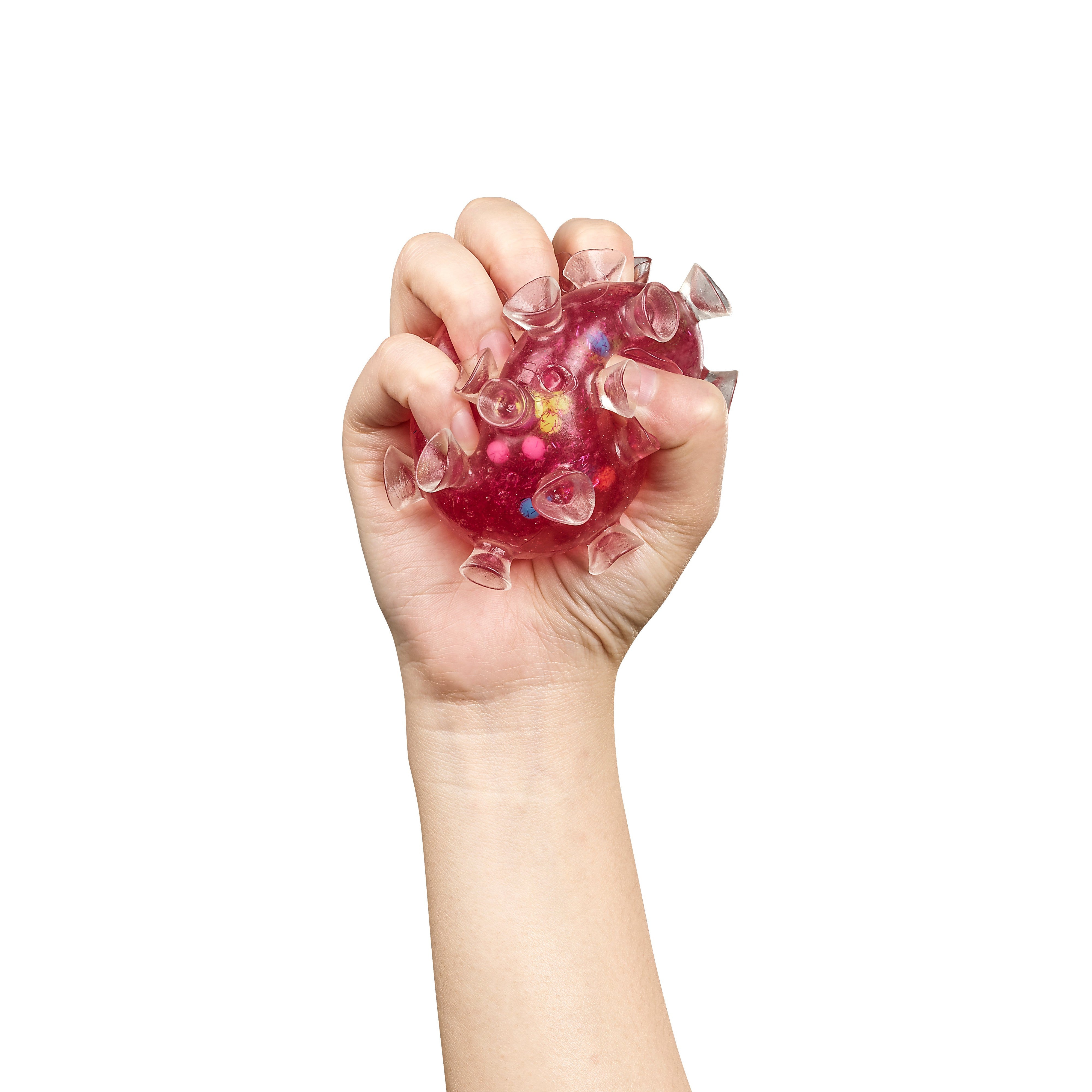A hand squeezes the Toysmith Squishy Sucker Ball by Toysmith, a red, spiky, translucent sensory toy with small protrusions, shown isolated on a white background.