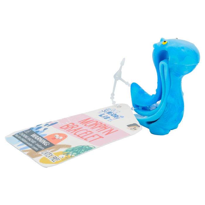 A blue cartoon snail toy holds a colorful tag labeled "Sensory Lab Morphin' Bracelet," a wearable fidget and sensory bracelet by Sensory Lab, featuring animal illustrations and a warning label, shown on a white background.