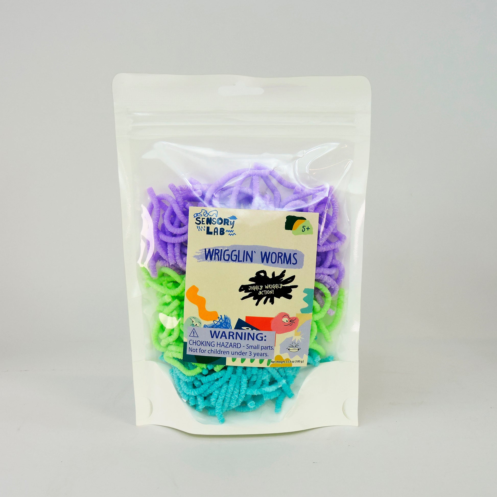 Sensory Lab Wrigglin Worms come in a clear package with textured, colorful worm toys in purple, green, and blue. The packaging has a choking hazard warning and is recommended for ages 5+.