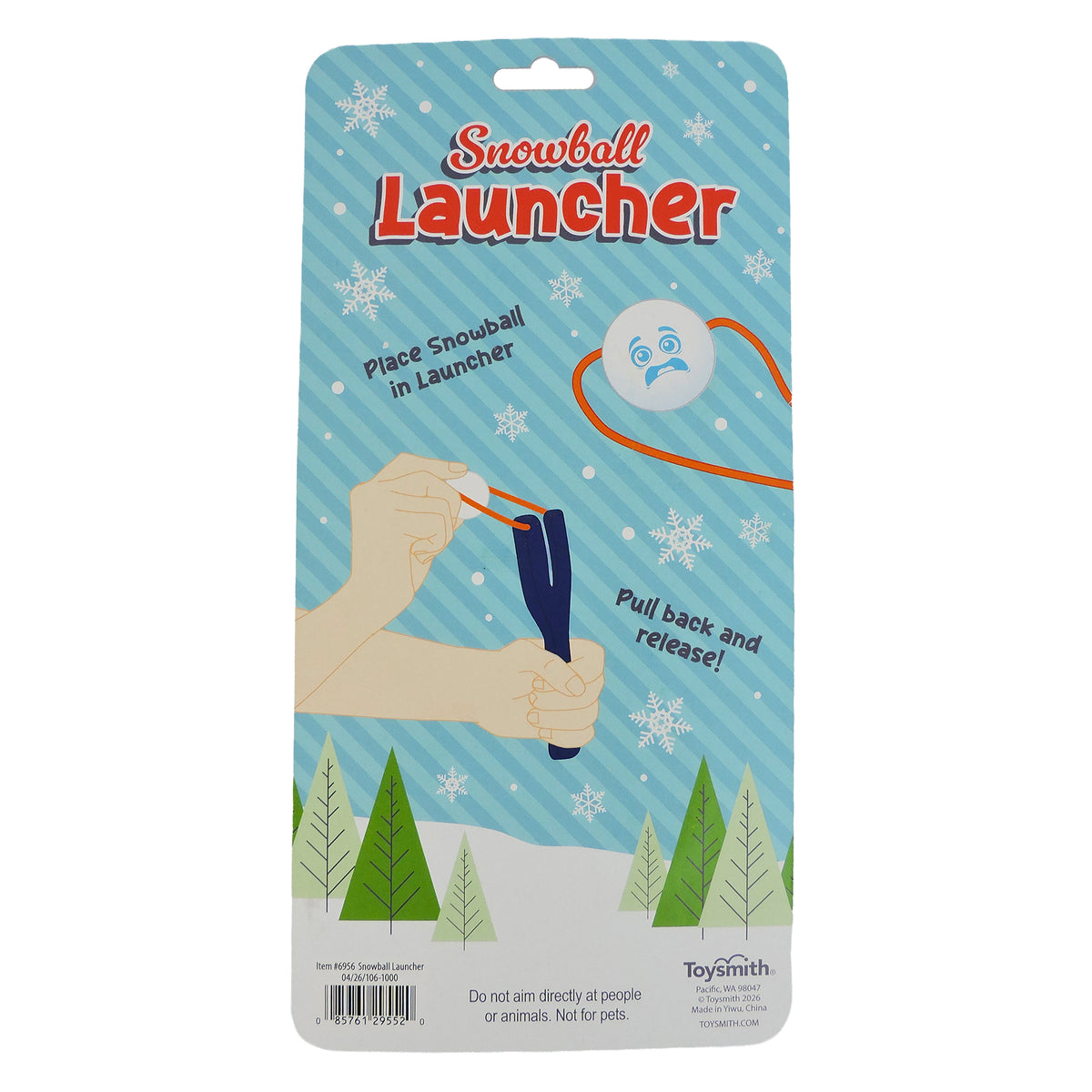 The Toysmith Snowball Launcher package features illustrated hands placing a snowball into the launcher with pull-and-release instructions, all set on a snowy background—perfect for holiday party games. Brand: Toysmith.