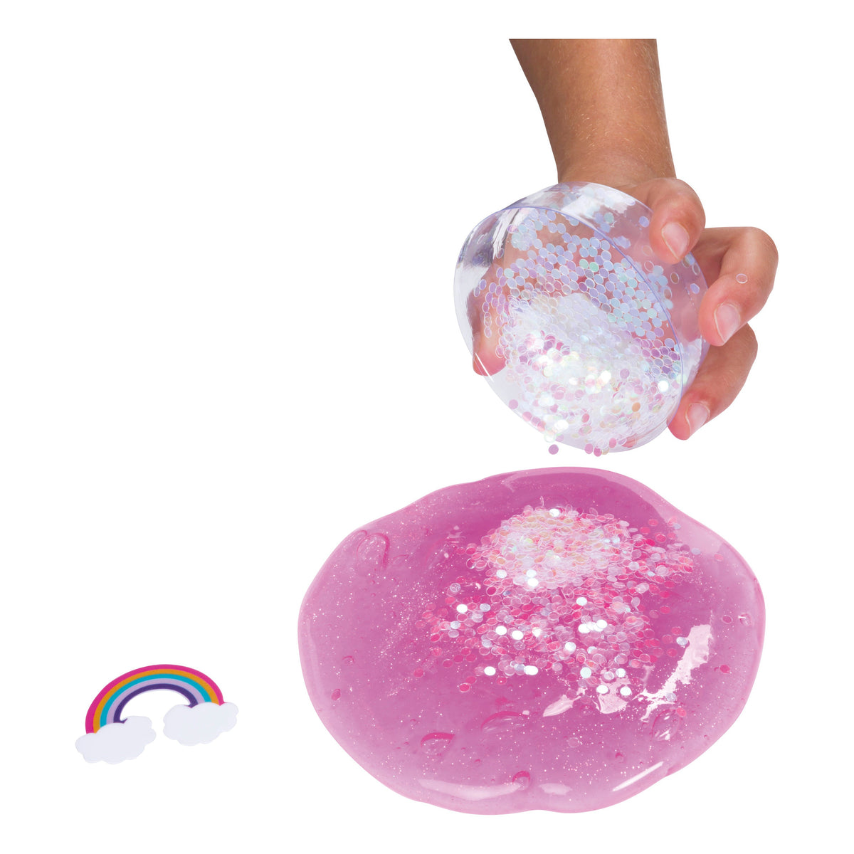 A hand holds clear, glittery slime from the Toysmith Mix-Ins Slime Asst by Toysmith over pink sparkly slime. Colorful mix-ins and a small rainbow with white clouds add extra fun nearby.