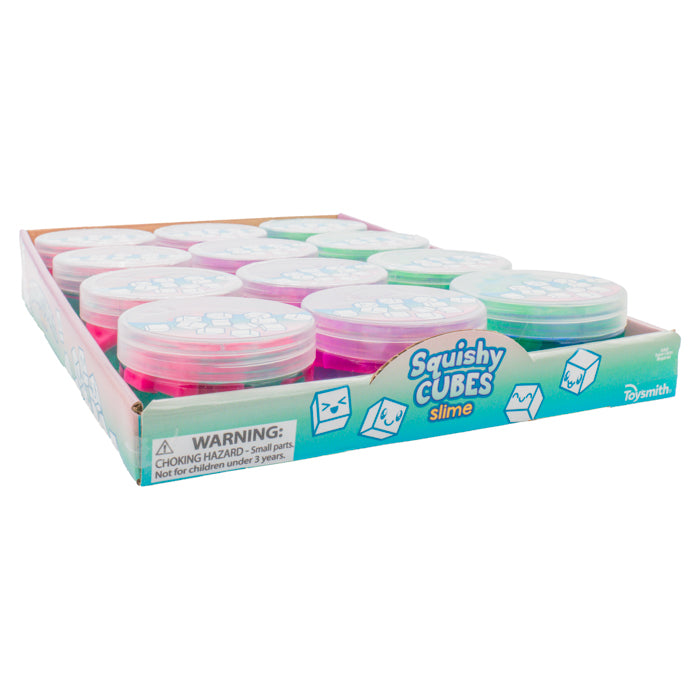 A Toysmith Squishy Cube Slime display box features sensory toys in assorted colors with clear plastic lids. The blue-branded box warns that the slime poses a choking hazard for children under 3 years.