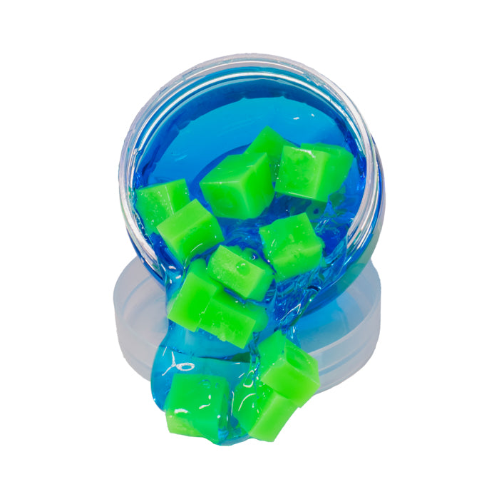 A small jar from Toysmith spills bright blue Squishy Cube Slime with green cubes onto a clear lid, all set against a white background. This sensory toy offers hands-on fun.