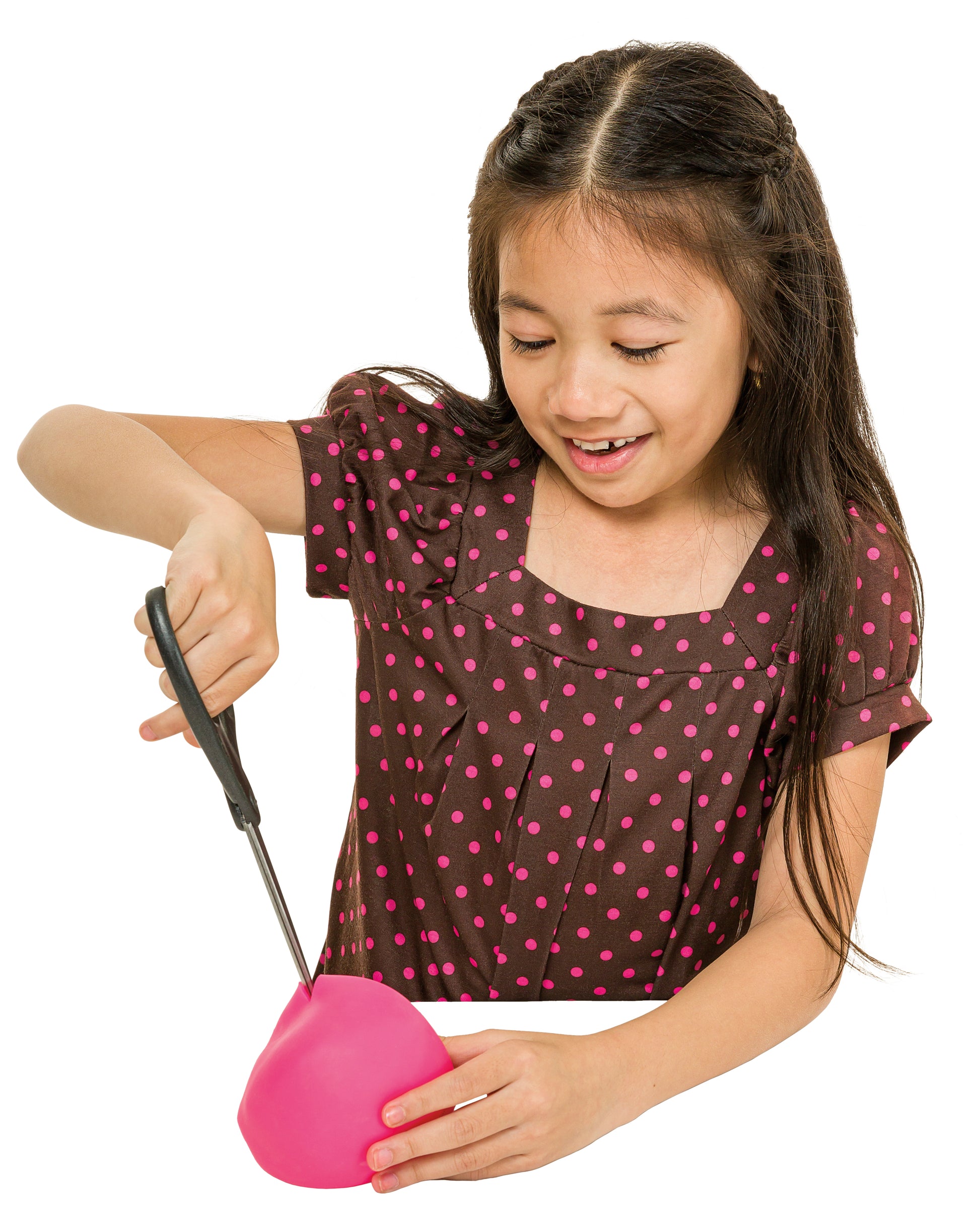 A young girl with long dark hair, dressed in a brown shirt with pink polka dots, smiles as she cuts open an Oddly Satisfying Surprise N' Slime Mystery Ball with scissors.