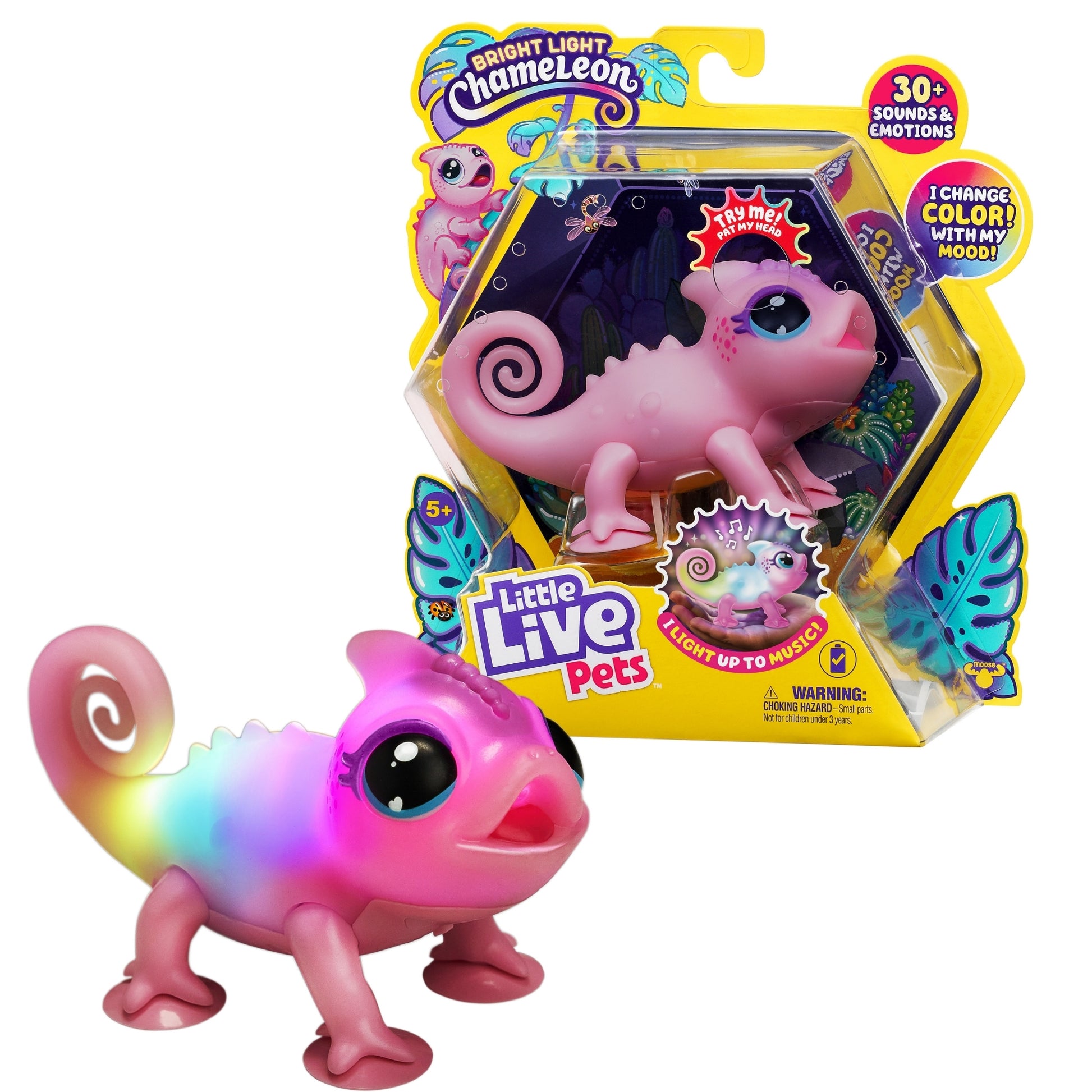 The Moose Toys Little Live Pets S2 Lil’ Chameleon, a pink interactive toy with multicolor glowing lights on its back, stands before packaging decorated with butterflies and colorful graphics highlighting its mood and sound features.