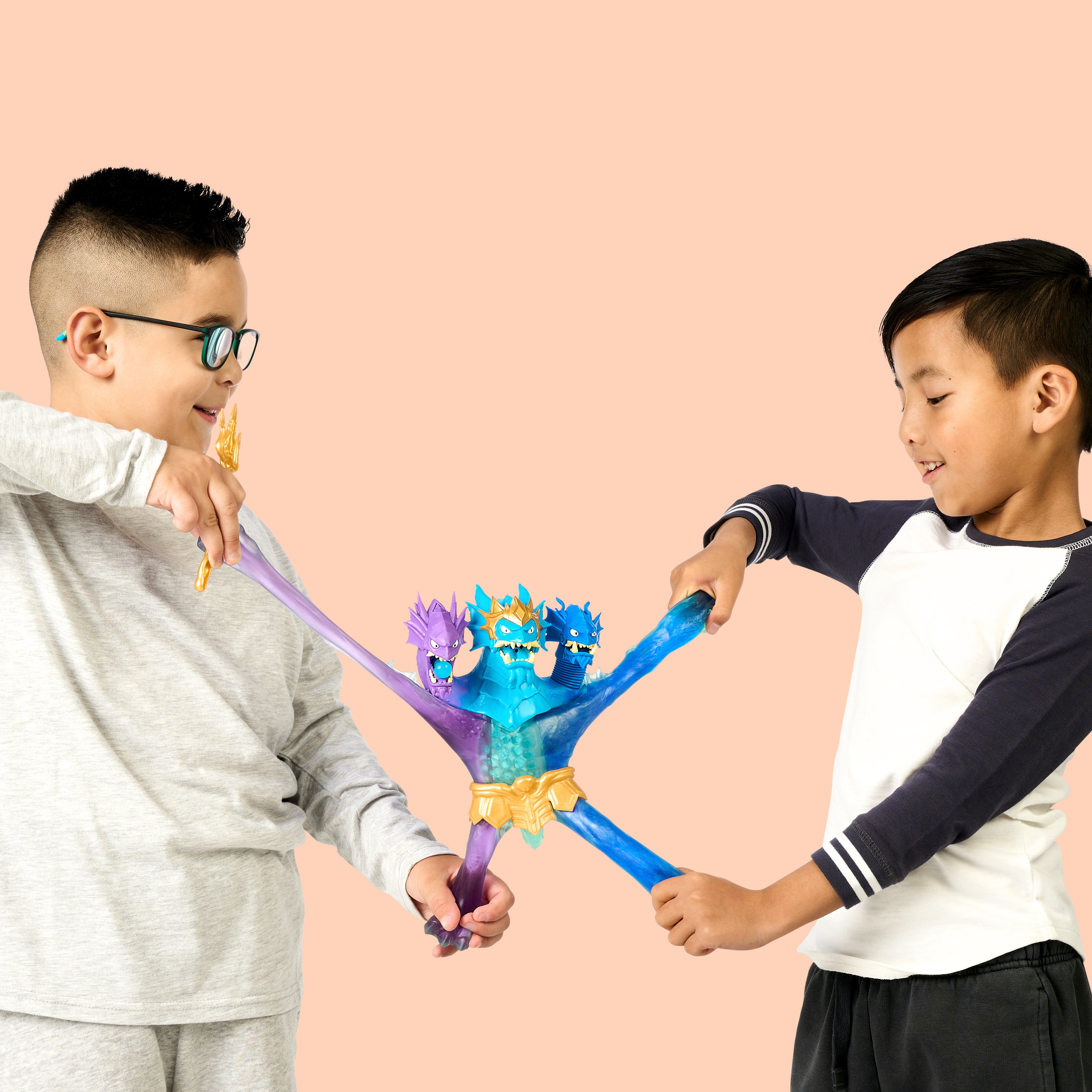 Two children playing with toy swords against a pink background