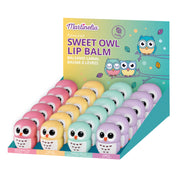Martinelia Sweet Owl Lip Balm by Martinelia: a fruity balm collection in pastel owl-shaped containers (pink, yellow, green, purple) with watermelon, cream, green apple & grape flavors—displayed against a colorful owl-themed backdrop.