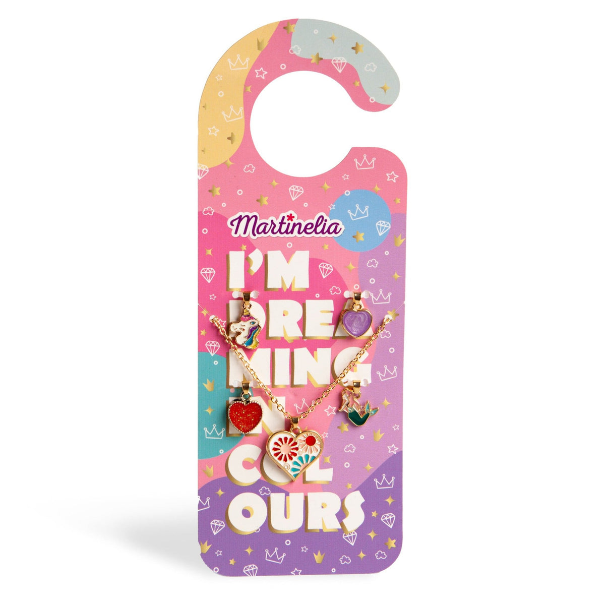 Martinelia Door Hanger Necklaces features a colorful hanger-shaped card with cute drawings, the phrase "IM DREAMING COLOURS," and displays three gold-tone necklaces with heart, unicorn, and strawberry charms.
