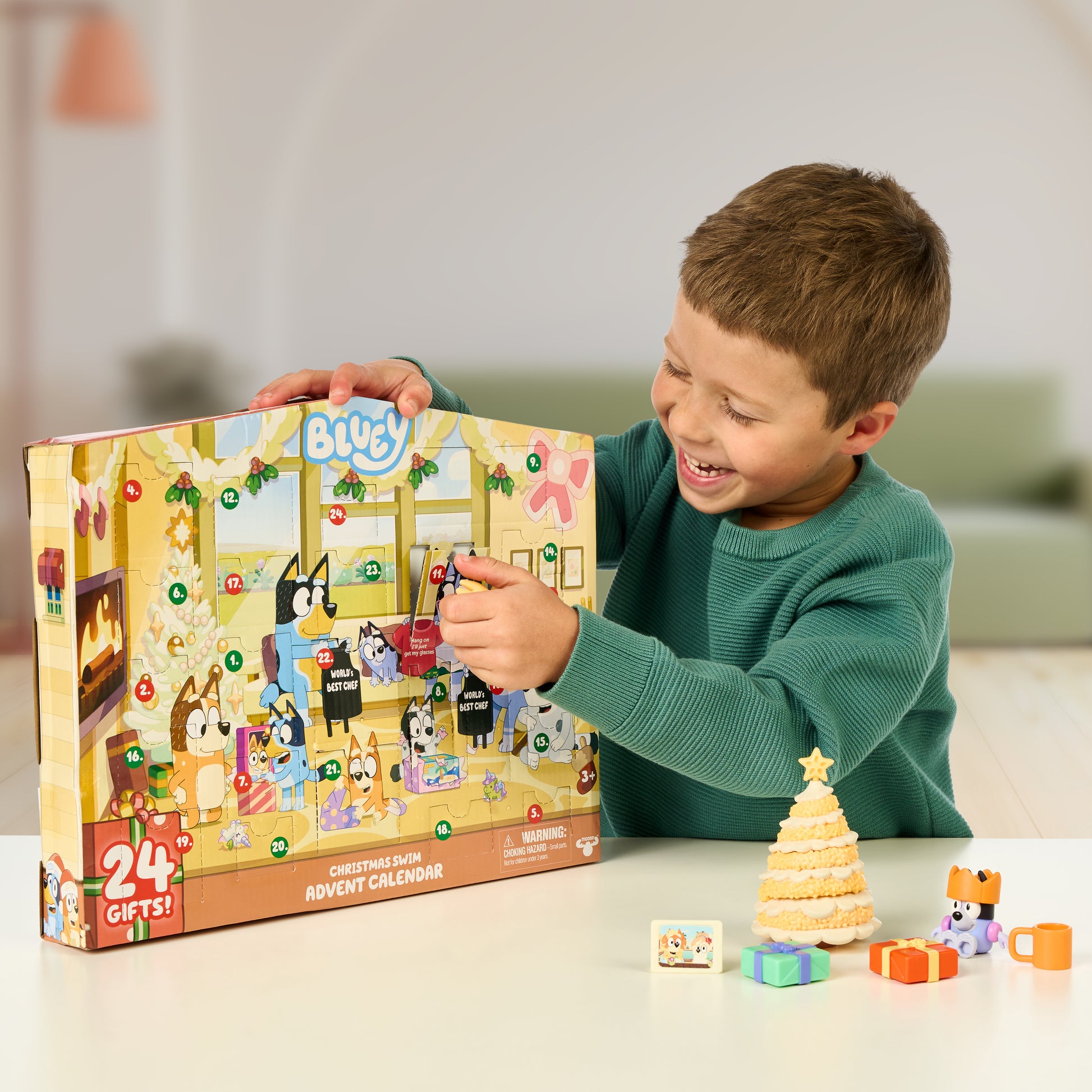 Child opening a Blue's Clues advent calendar with small toys around