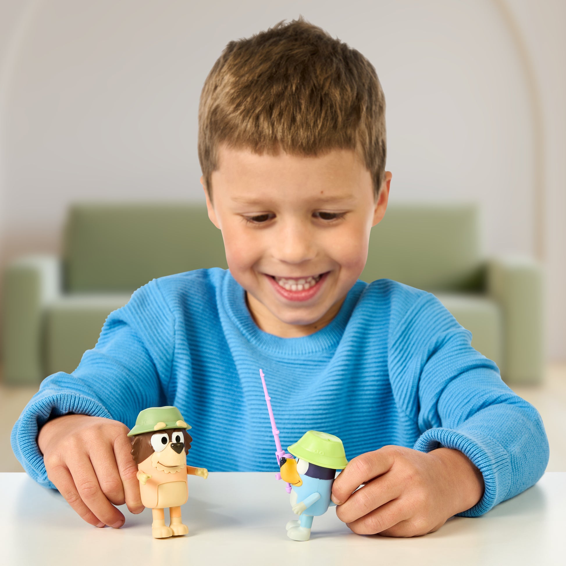 Child playing with Bluey figures on a table