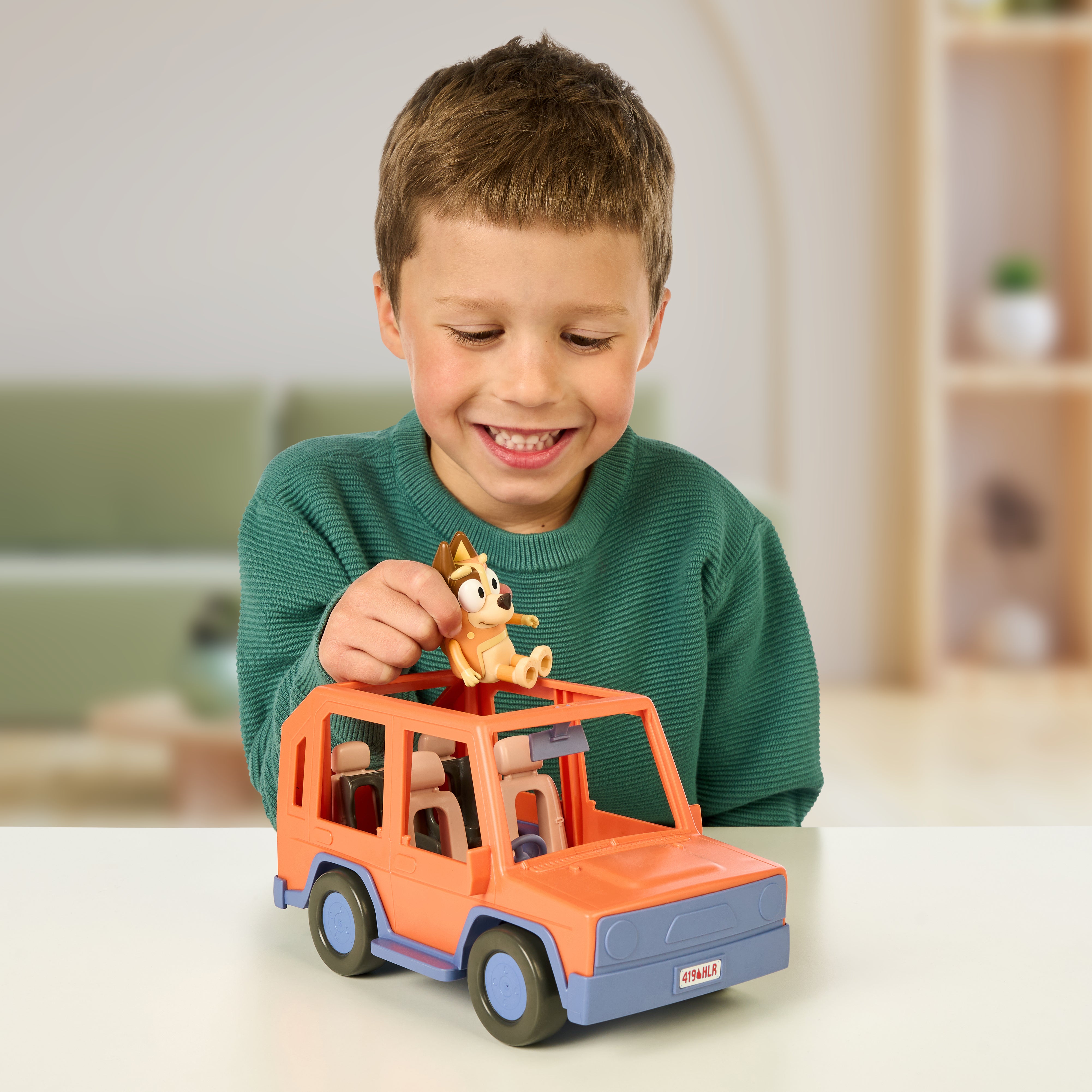 Child playing with Bluey 4WD Family Vehicle Playset