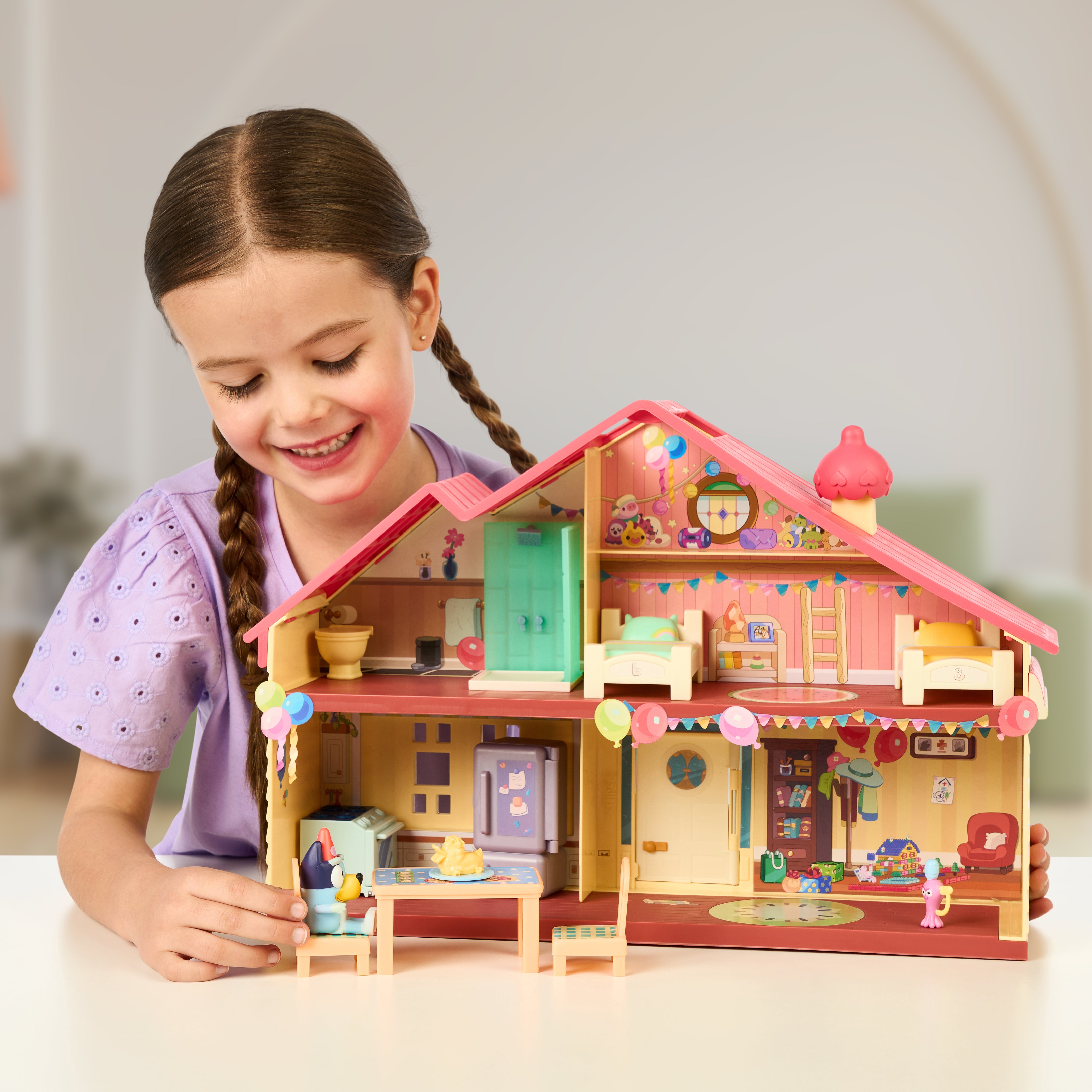 Young girl playing with Bluey's Celebration House