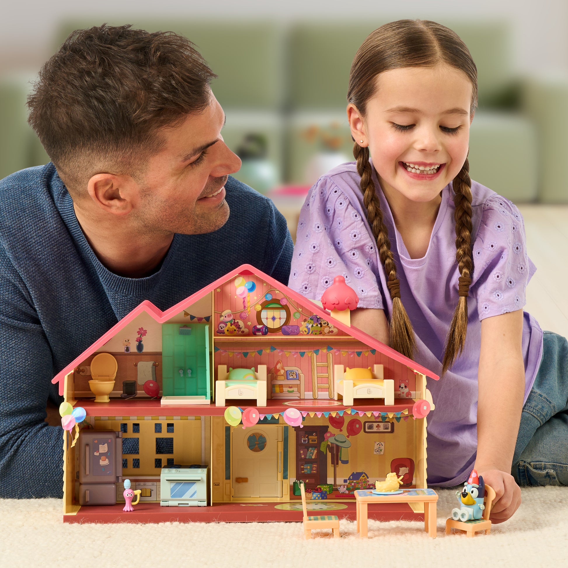 Father and daughter playing with Bluey's Celebration House