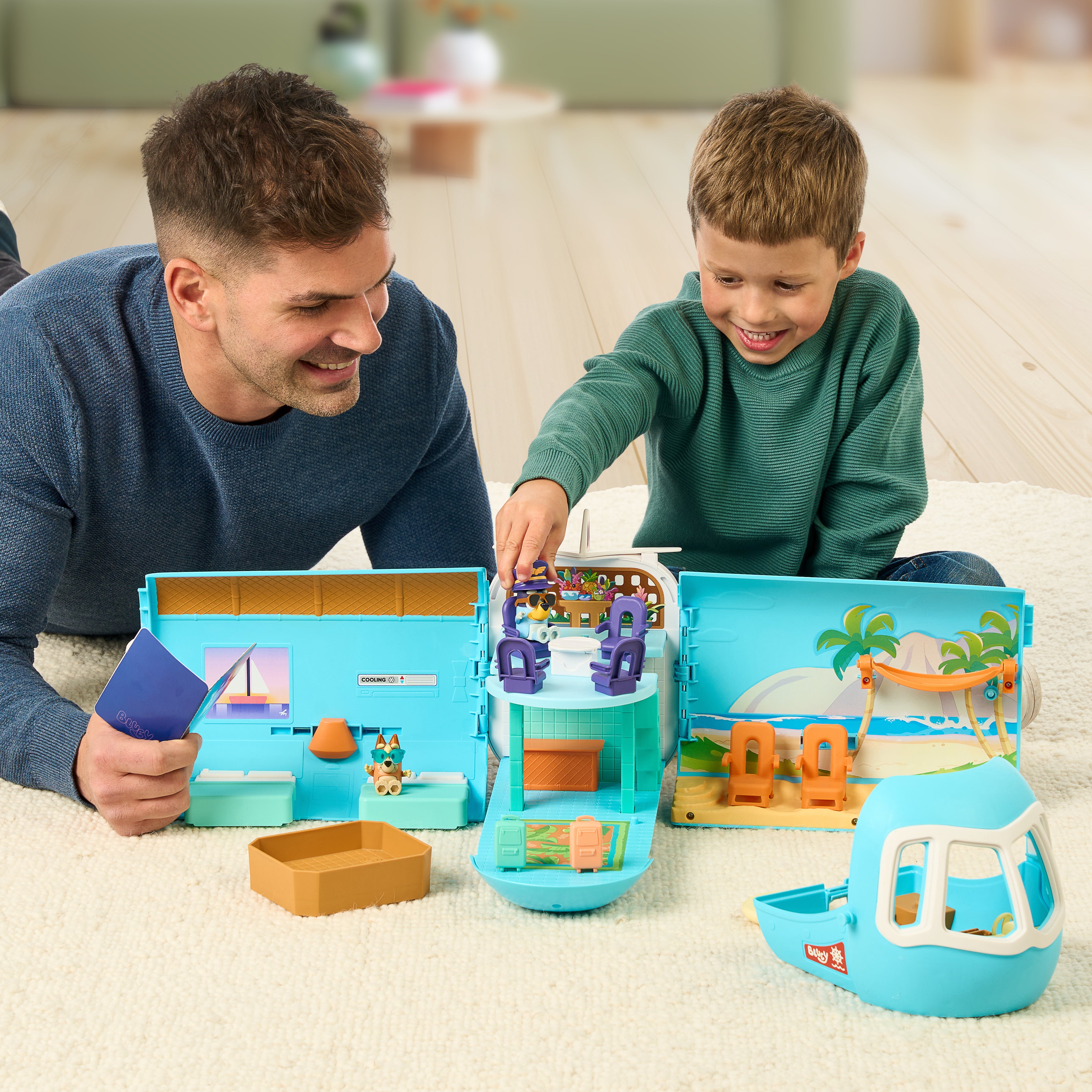 Man and child playing with a toy set on the floor