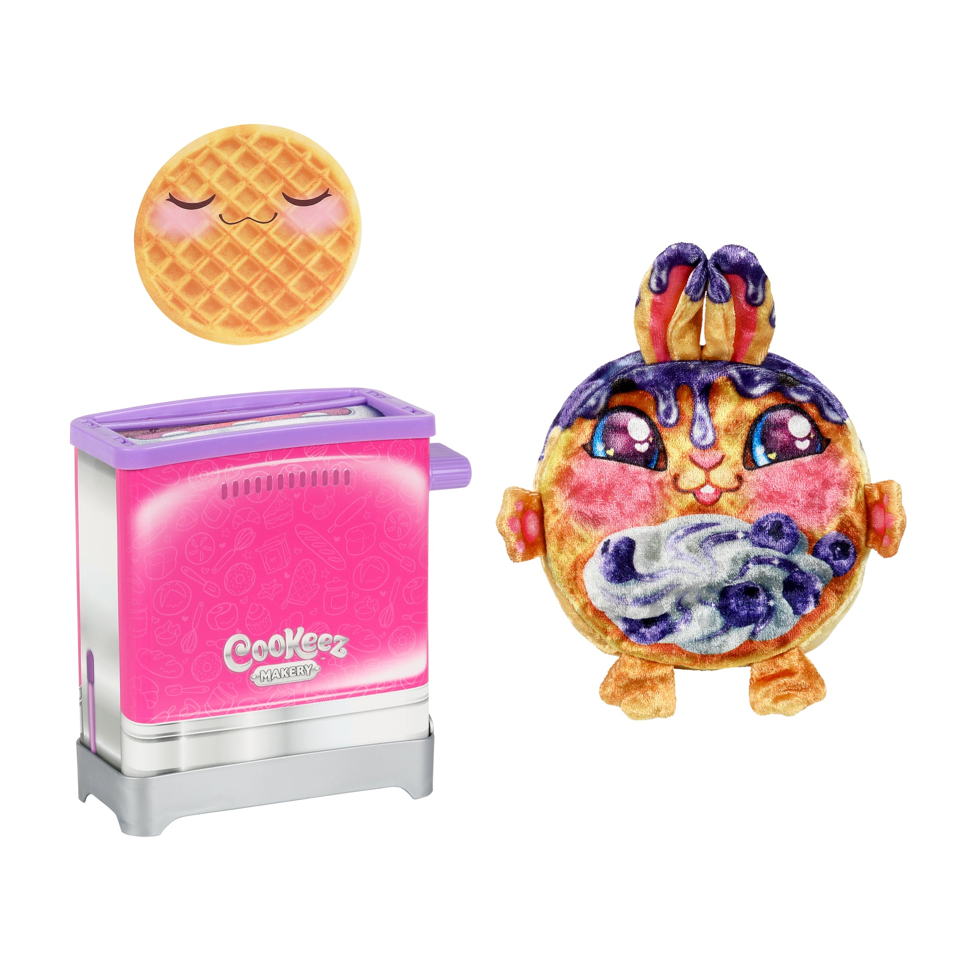 The Cookeez Makery Toasty Treatz features a pink toy toaster with the logo, next to a plush waffle character topped with syrup and whipped cream, while a smiling waffle disc with closed eyes floats above.