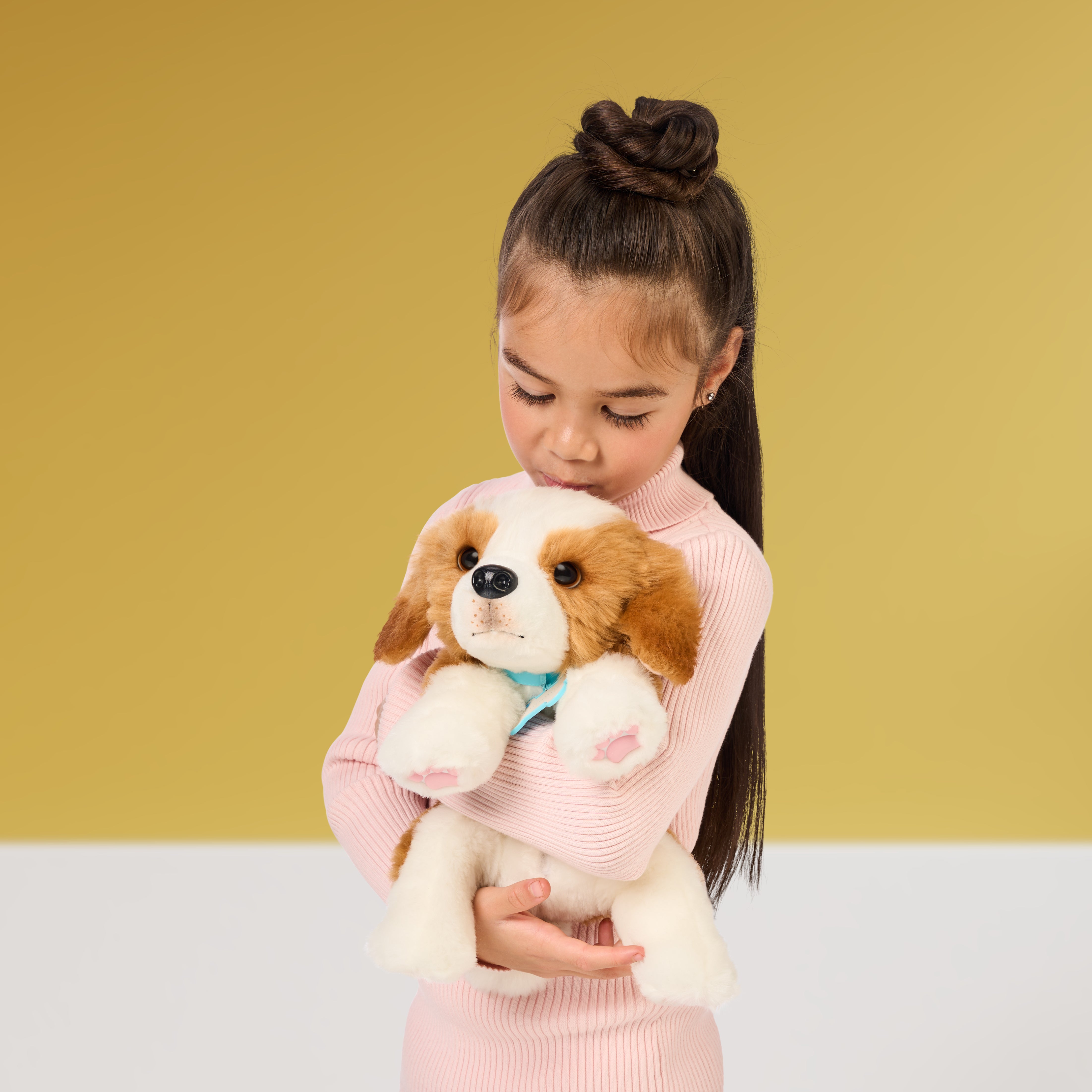 Child holding a plush dog toy against a yellow background