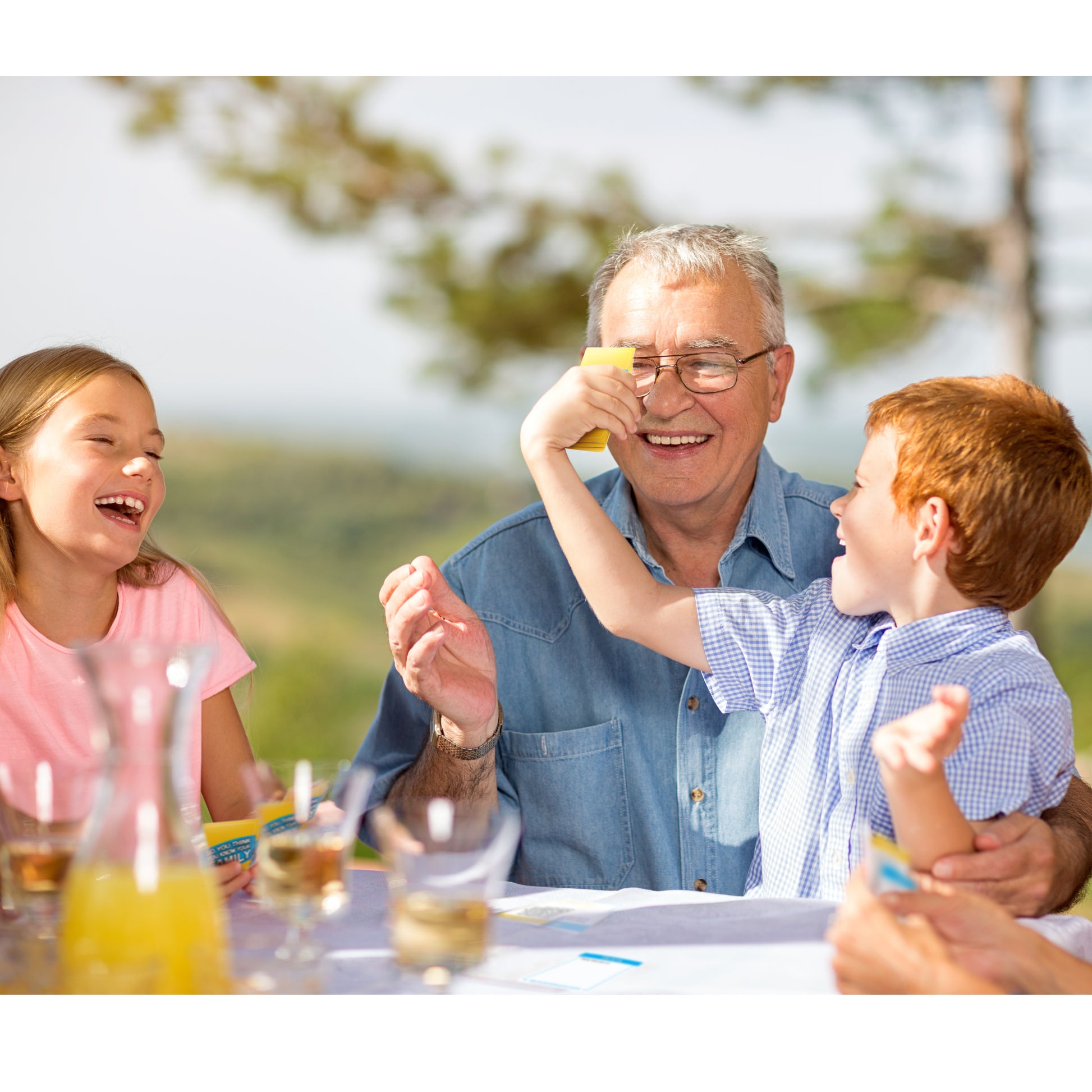 Grandfather and grandchildren enjoying a meal outdoors