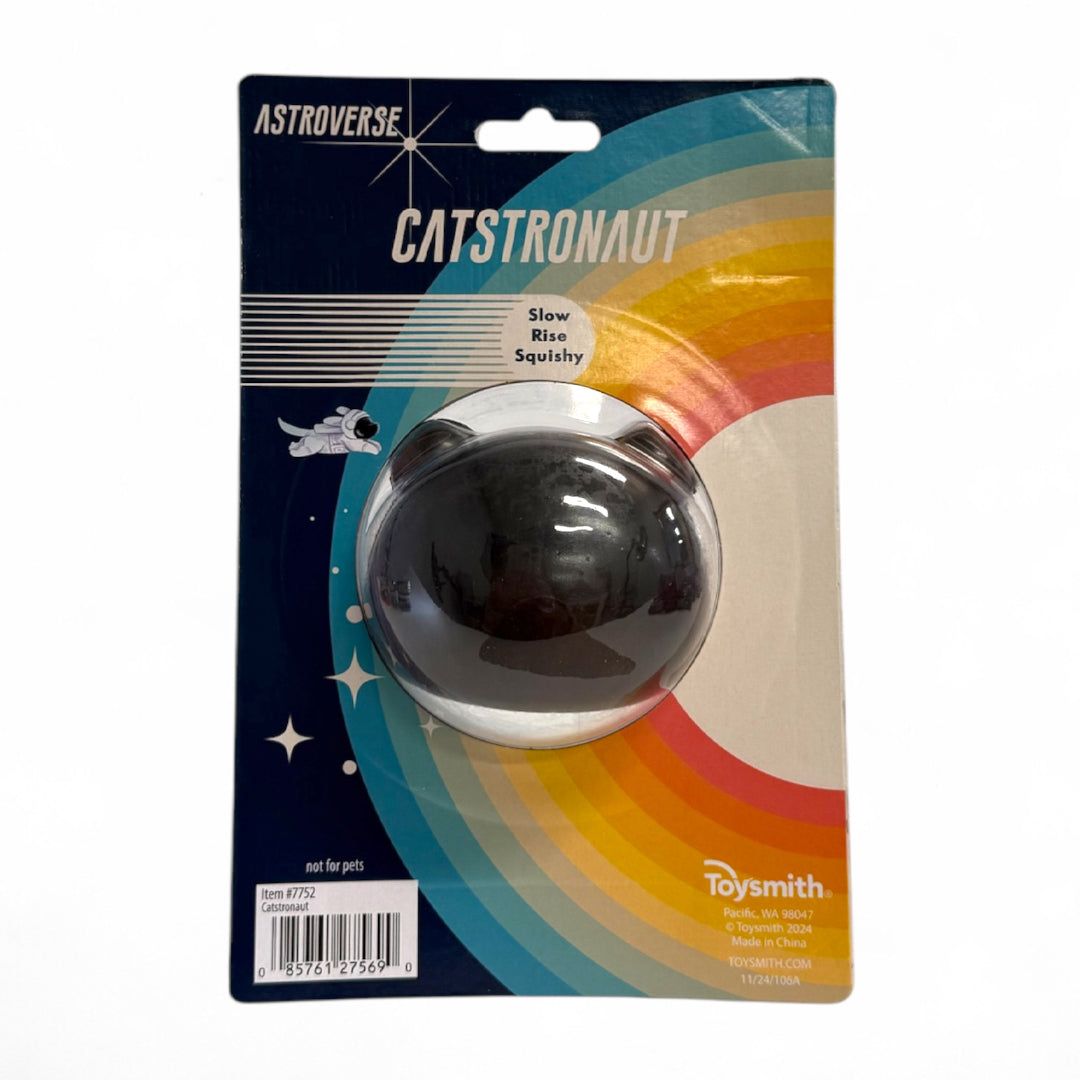 The Astroverse Catstronaut is a slow rise squishy ball shaped like a kitty astronaut’s head in a space helmet, packaged with retro rainbow and starburst backing—a fun grip strength toy.