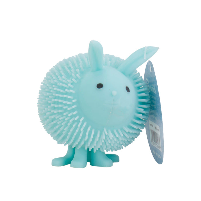 The Toysmith Light-Up Squishies by Toysmith is a light blue, round animal-shaped rubber toy with bunny ears, tiny legs, a round nose, black eyes, and a spiky surface—great for sensory play. A blue tag hangs from one ear.