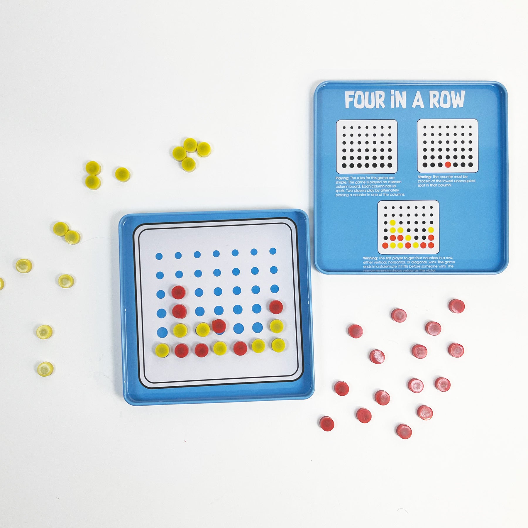 The open On the Way Games Magnetic 4 In A Row features red and yellow pieces on a magnetic board, with extra pieces beside it. Game instructions and diagrams are printed inside the lid for easy play while traveling.