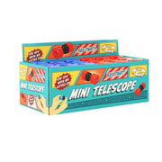 A colorful display box labeled Toysmith Mini Telescopes, from the Toysmith brand, contains small red and blue mini telescopes ideal for kids’ outdoor discovery. The box features hand illustrations and playful text such as “SEE THAT?” and “EYE SPY WITH MY LITTLE EYE.”.