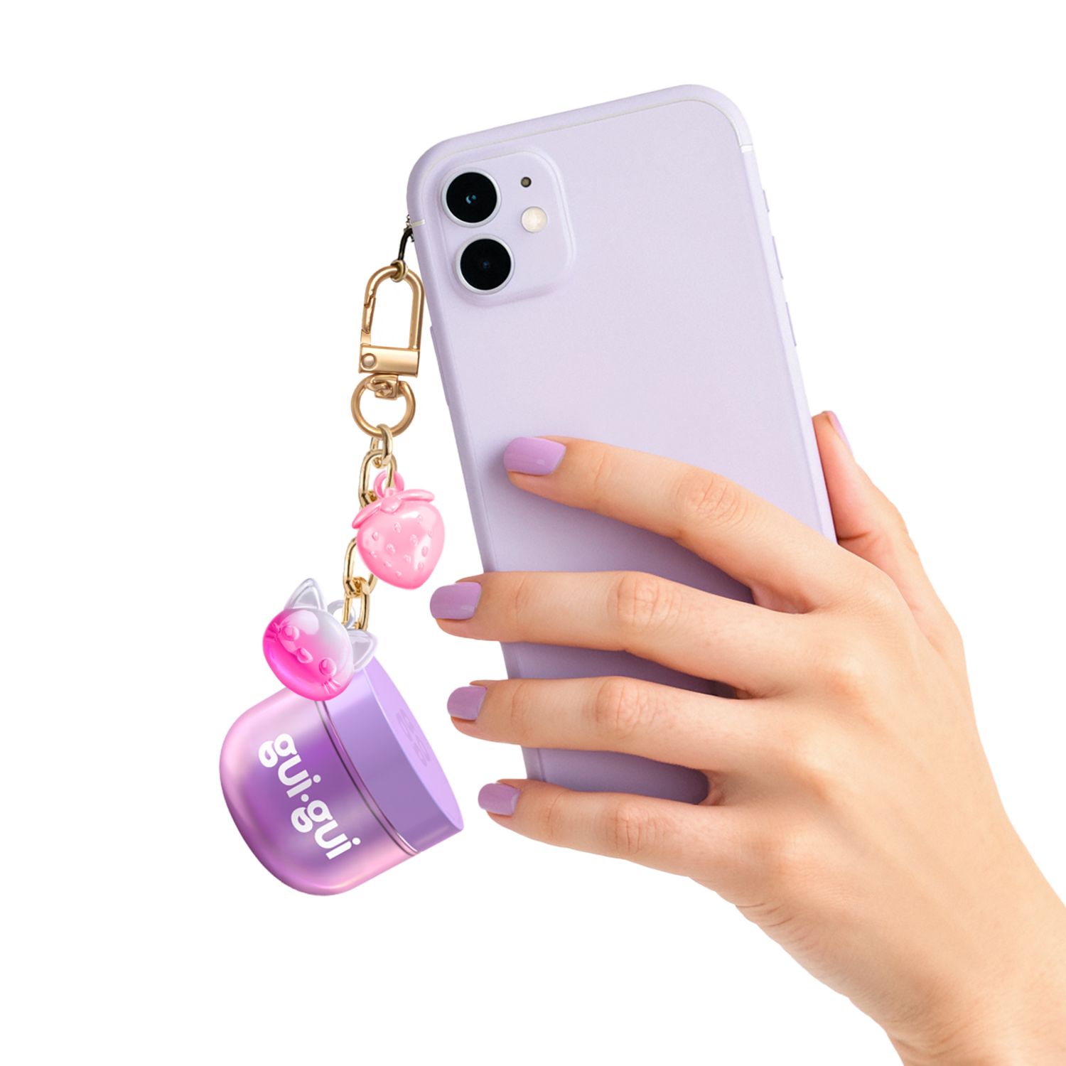 A hand with lavender-painted nails holds a lavender smartphone with a keychain featuring a Moose Toys Gui Gui Mini Backpack Charm Slime and two pink bear-shaped charms.