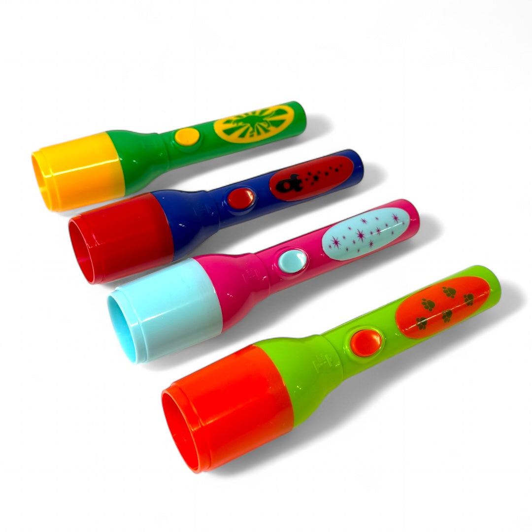 Four Toysmith Mini LED Flashlight Projectors by Toysmith, each with unique colors, button styles, and image disks, are displayed in a row on a white background. Each mini projector features bright patterns and playful designs.